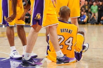 LOS ANGELES, CA - APRIL 12: Kobe Bryant #24 of the Los Angeles Lakers speaks with teammates Pau Gasol #16 and Steve Blake #5 after getting injured during a game against the Golden State Warriors at Staples Center on April 12, 2013 in Los Angeles, Californ