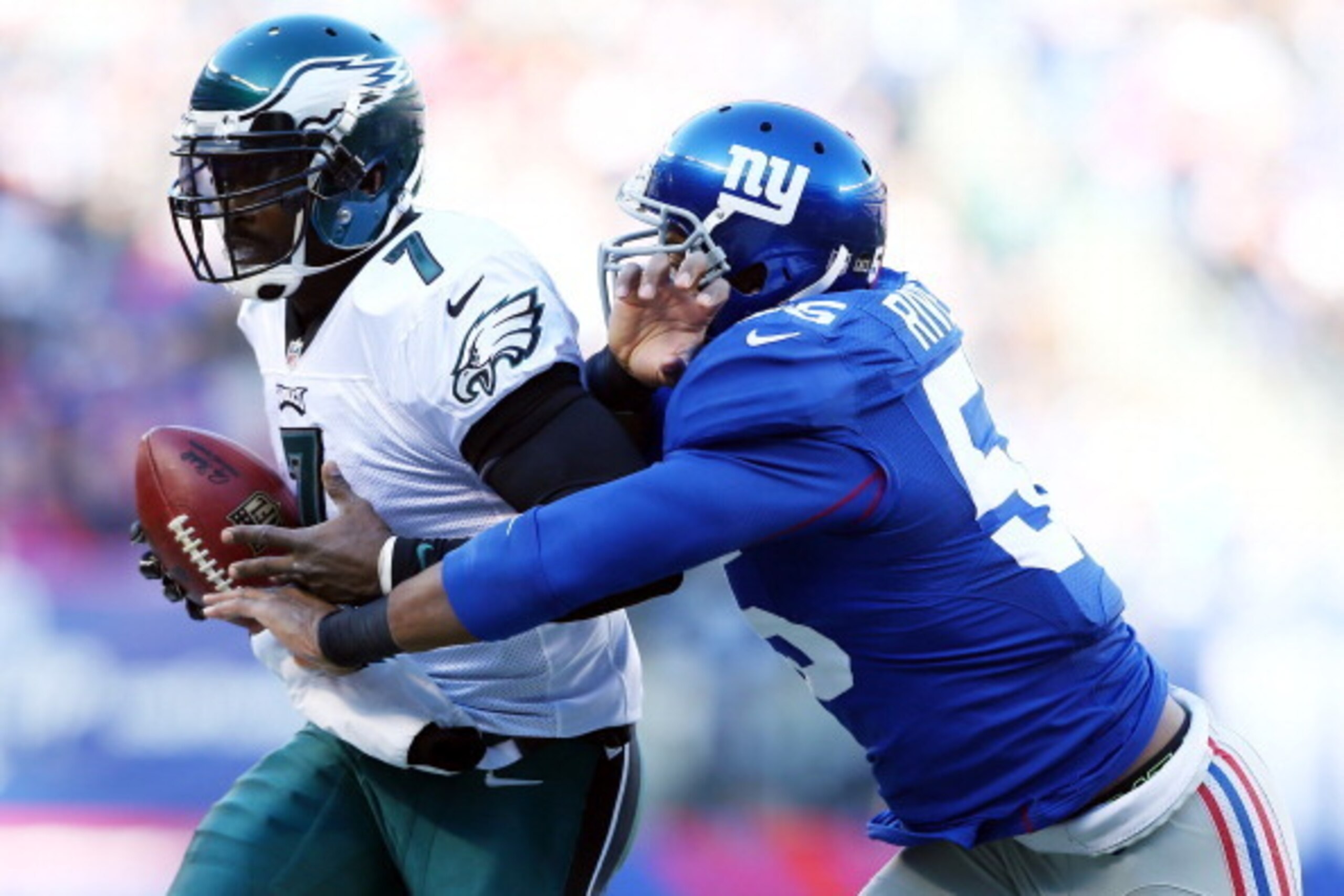 EAST RUTHERFORD, NJ - DECEMBER 30:  Michael Vick #7 of the Philadelphia Eagles is pushed out of bounds by Keith Rivers #55 of the New York Giants at MetLife Stadium on December 30, 2012 in East Rutherford, New Jersey.  (Photo by Elsa/Getty Images)