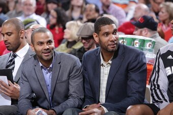 PORTLAND, OR - FEBRUARY 19:  Tony Parker #9 and Tim Duncan #21 of the San Antonio Spurs talk on the bench against the Portland Trail Blazers on February 19, 2014 at the Moda Center Arena in Portland, Oregon. NOTE TO USER: User expressly acknowledges and a