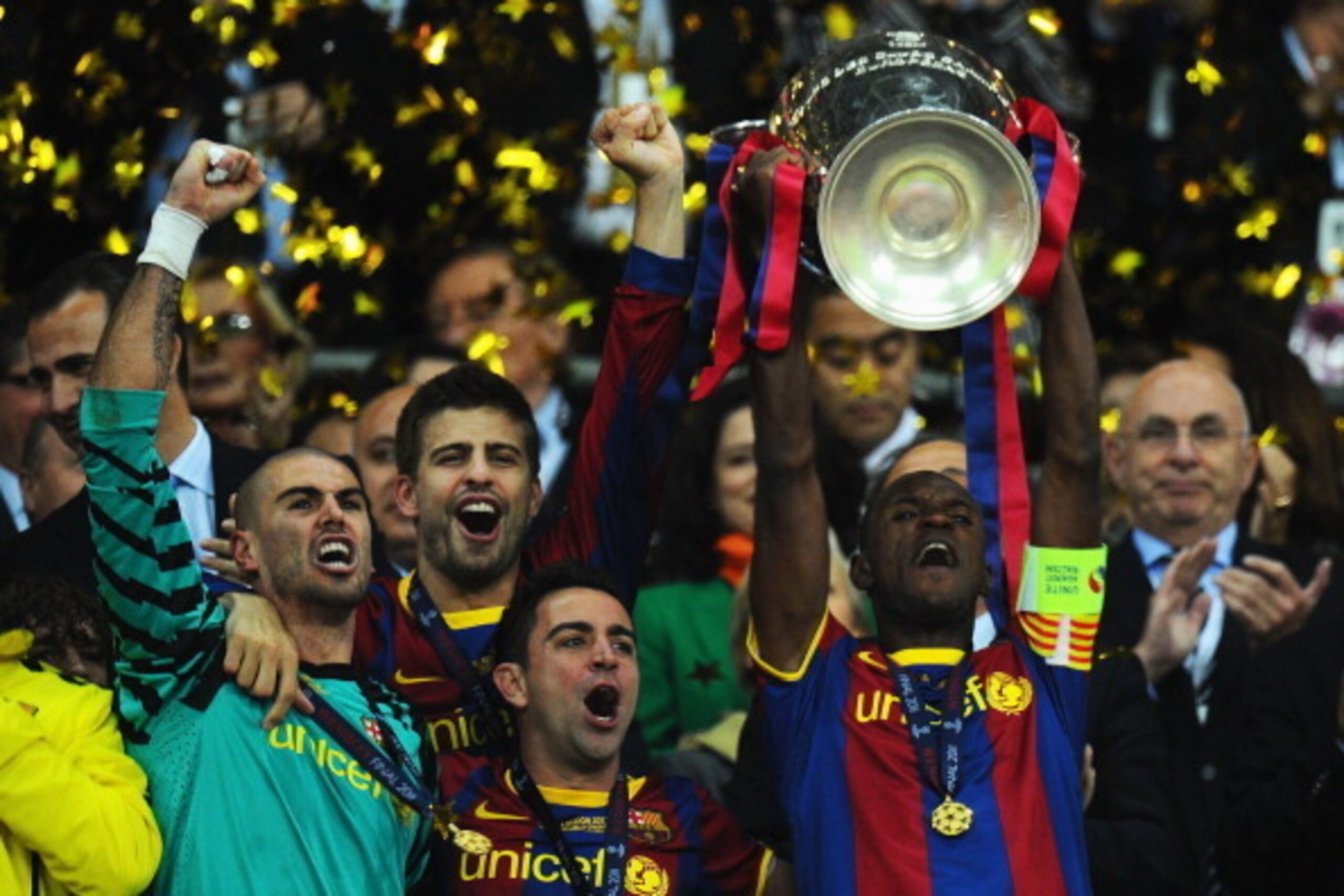 LONDON, ENGLAND - MAY 28: (L-R) Victor Valdes, Gerard Pique and Xavi celebrate as teammate Eric Abidal of FC Barcelona lifts the trophy during the UEFA Champions League final between FC Barcelona and Manchester United FC at Wembley Stadium on May 28, 201 LONDON, ENGLAND - MAY 28: (L-R) Victor Valdes, Gerard Pique and Xavi celebrate as teammate Eric Abidal of FC Barcelona lifts the trophy during the UEFA Champions League final between FC Barcelona and Manchester United FC at Wembley Stadium on May 28, 201
