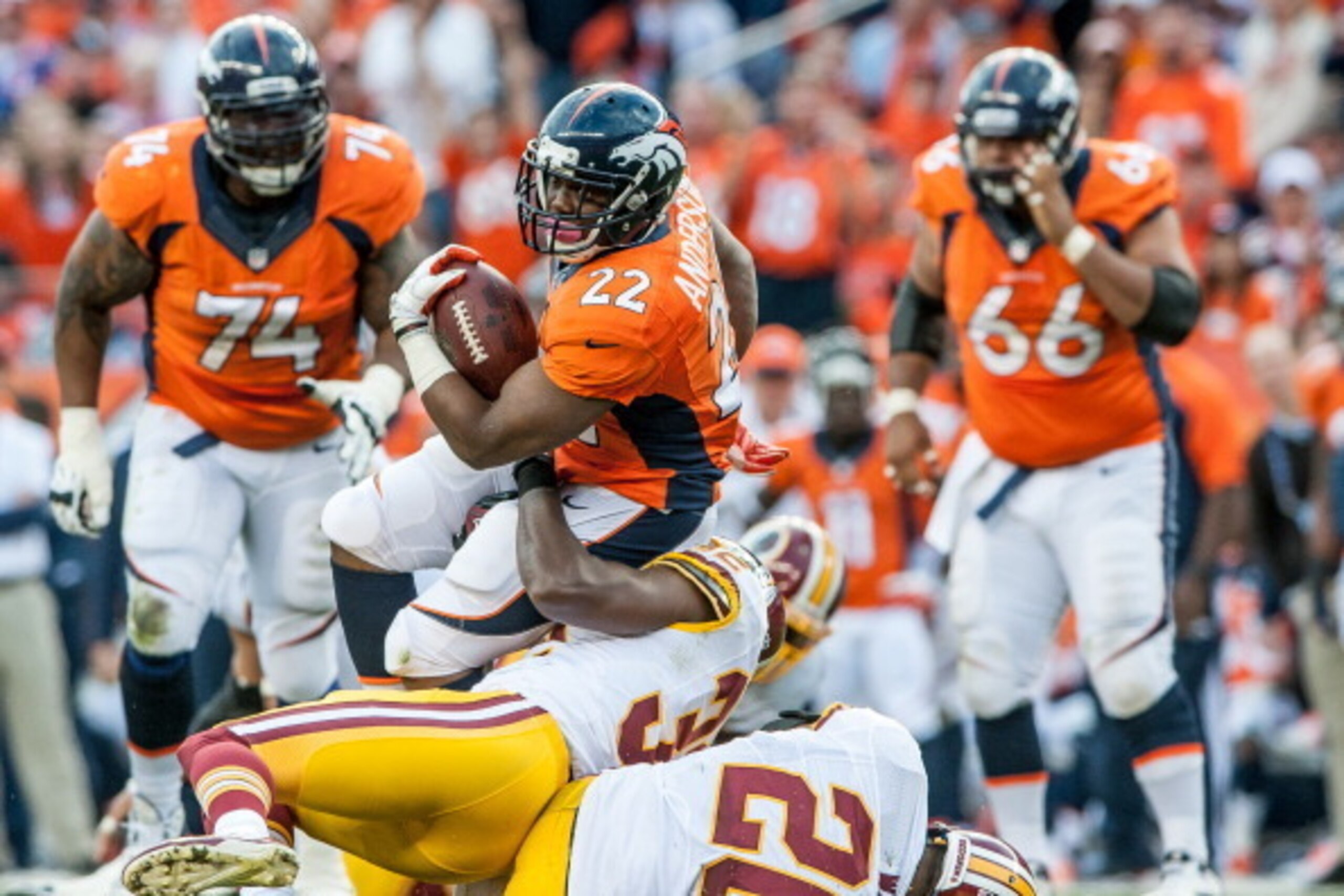 DENVER, CO - OCTOBER 27:  Running Back C.J. Anderson #22 of the Denver Broncos is tackled by defensive back Jordan Pugh #32 of the Washington Redskins in the fourth quarter of a game at Sports Authority Field Field at Mile High on October 27, 2013 in Denv