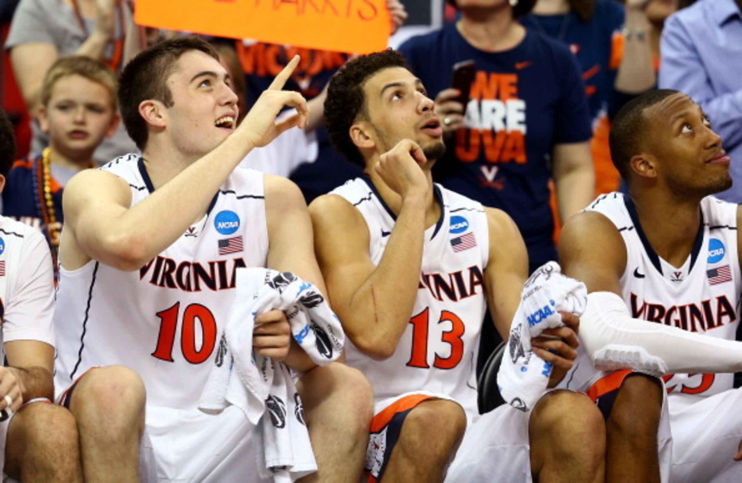 RALEIGH, NC - MARCH 23:  Mike Tobey #10, Anthony Gill #13 and Akil Mitchell #25 of the Virginia Cavaliers look on from the bench in the second half against the Memphis Tigers during the third round of the 2014 NCAA Men's Basketball Tournament at PNC Arena