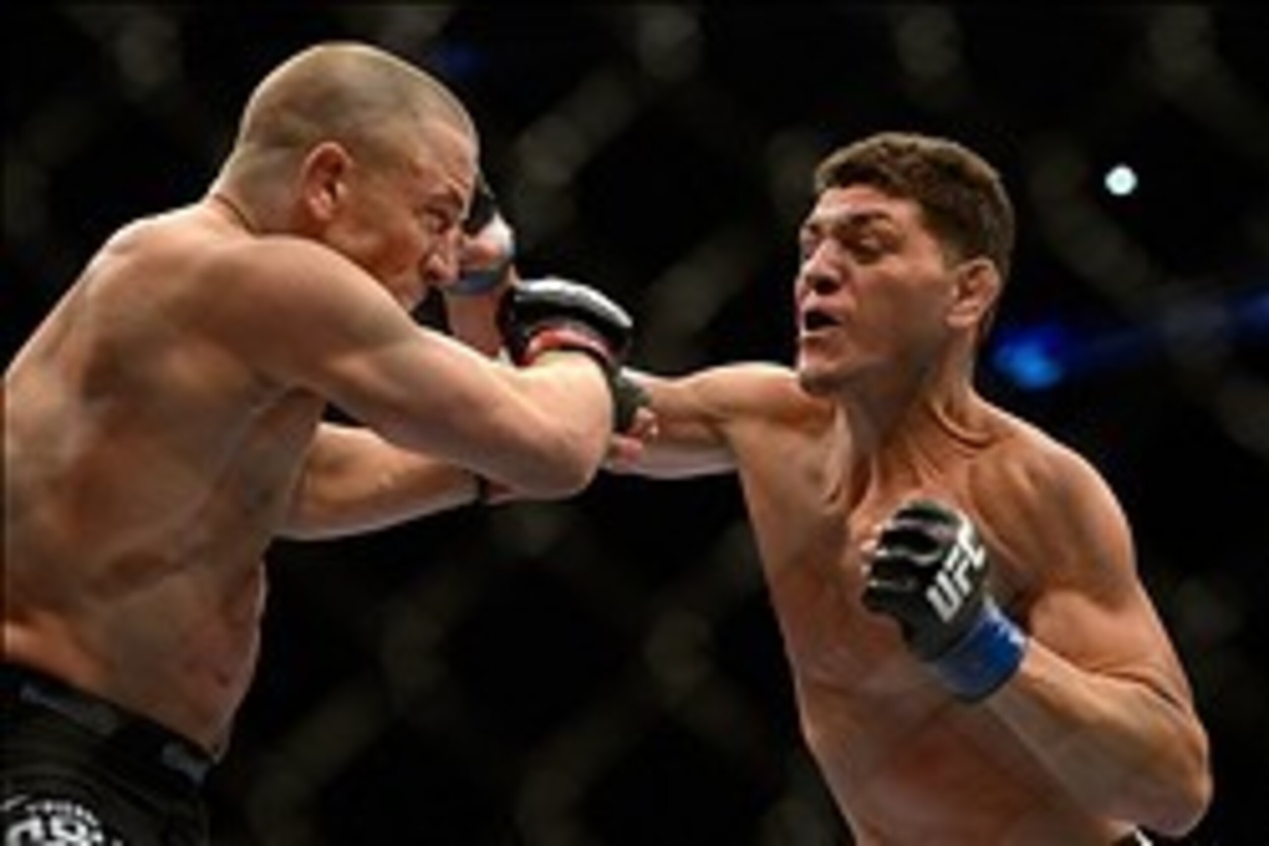 Mar 16, 2013; Montreal, Quebec, CAN;  Nick Diaz (blue) lands a punch on Georges St.Pierre (red) during their Welterweight title bout at UFC 158 at the Bell Centre. Mandatory Credit: Eric Bolte-USA TODAY Sports