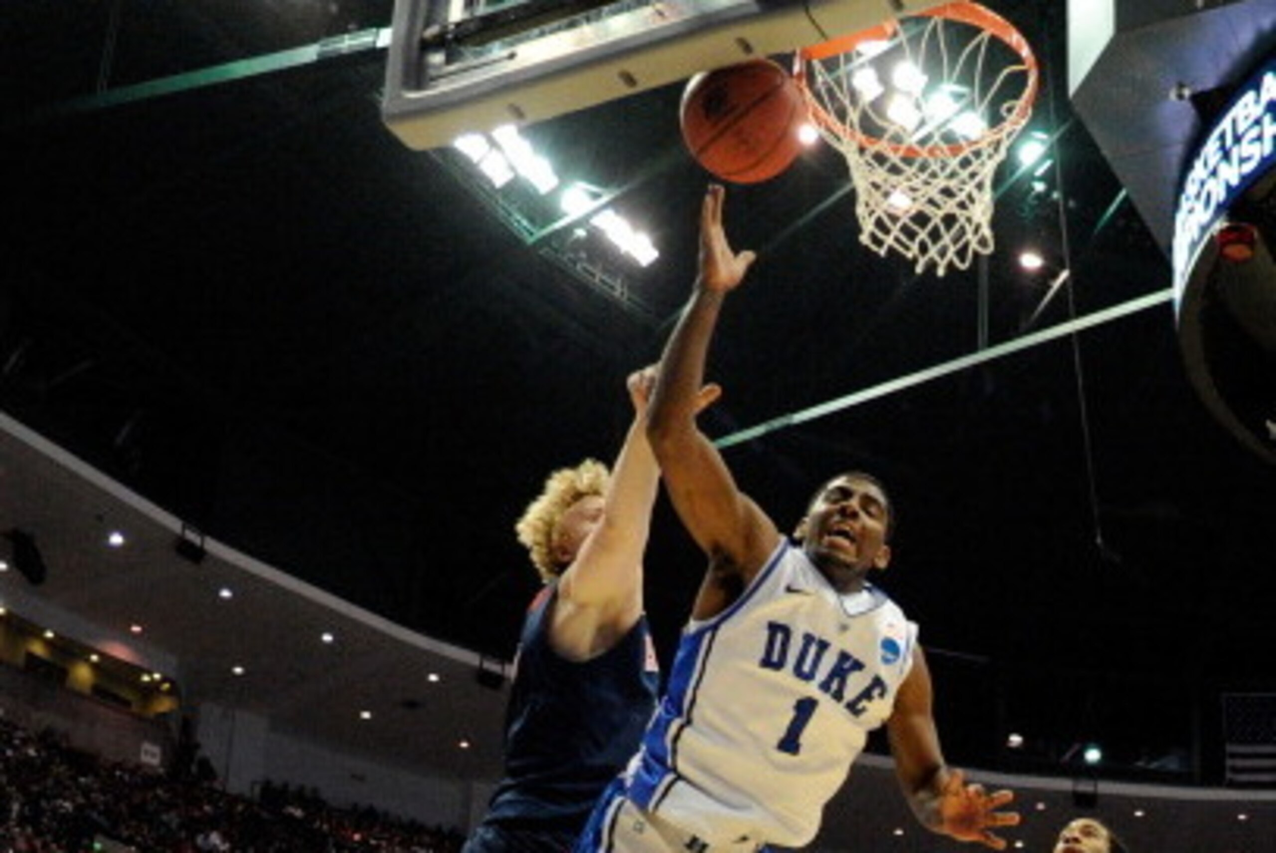 ANAHEIM, CA - MARCH 24:  Kyrie Irving #1 of the Duke Blue Devils draws contact against Kyryl Natyazhko #1 and Lamont Jones #12 of the Arizona Wildcats during the west regional semifinal of the 2011 NCAA men's basketball tournament at the Honda Center on M