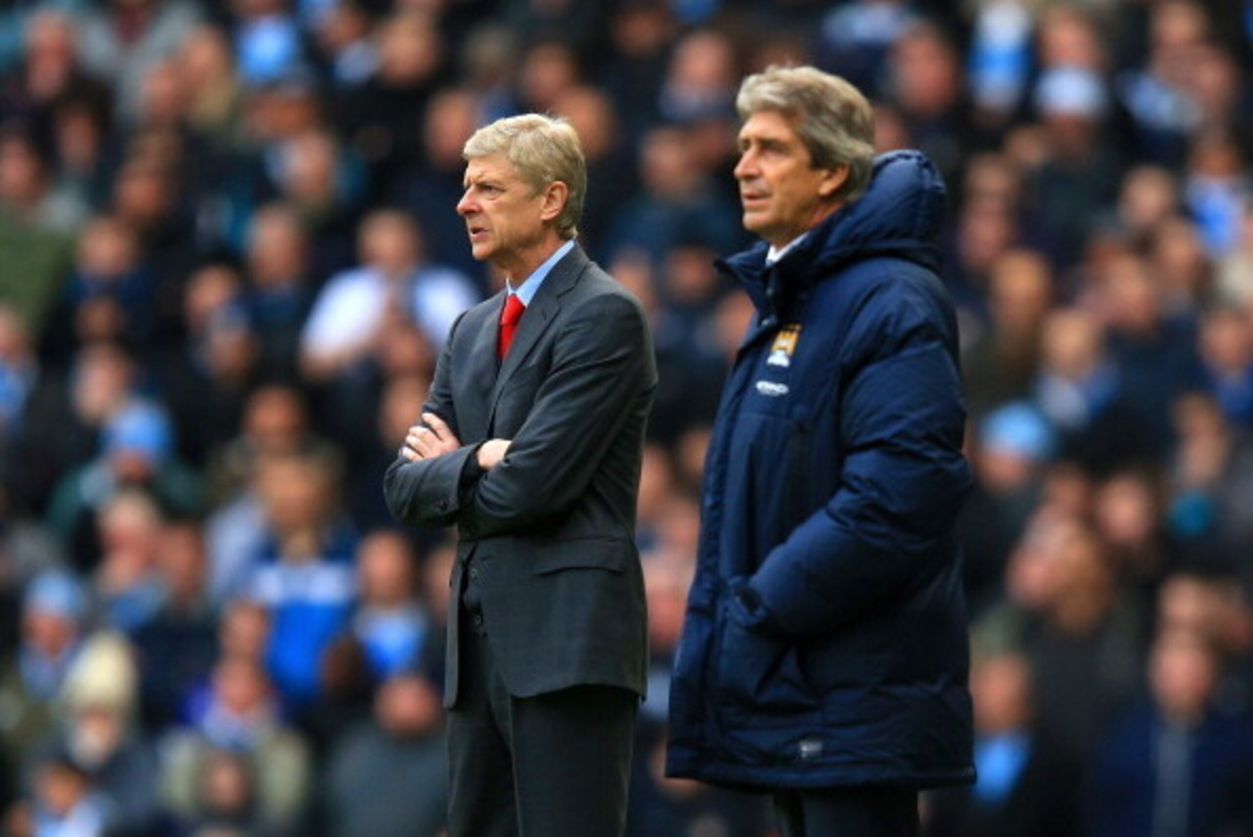 MANCHESTER, ENGLAND - DECEMBER 14:  Arsene Wenger manager of Arsenal and Manuel Pellegrini manager of Manchester City look on during the Barclays Premier League match between Manchester City and Arsenal at Etihad Stadium on December 14, 2013 in Manchester