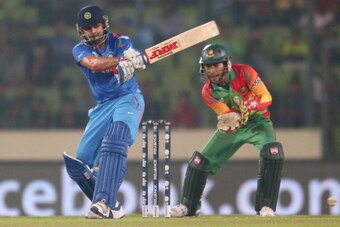 DHAKA, BANGLADESH - MARCH 28:  Virat Kohli of India bats as Mushfiqur Rahim of Bangladesh looks on during the ICC World Twenty20 Bangladesh 2014 match between Bangladesh and India at Sher-e-Bangla Mirpur Stadium on March 28, 2014 in Dhaka, Bangladesh.  (P