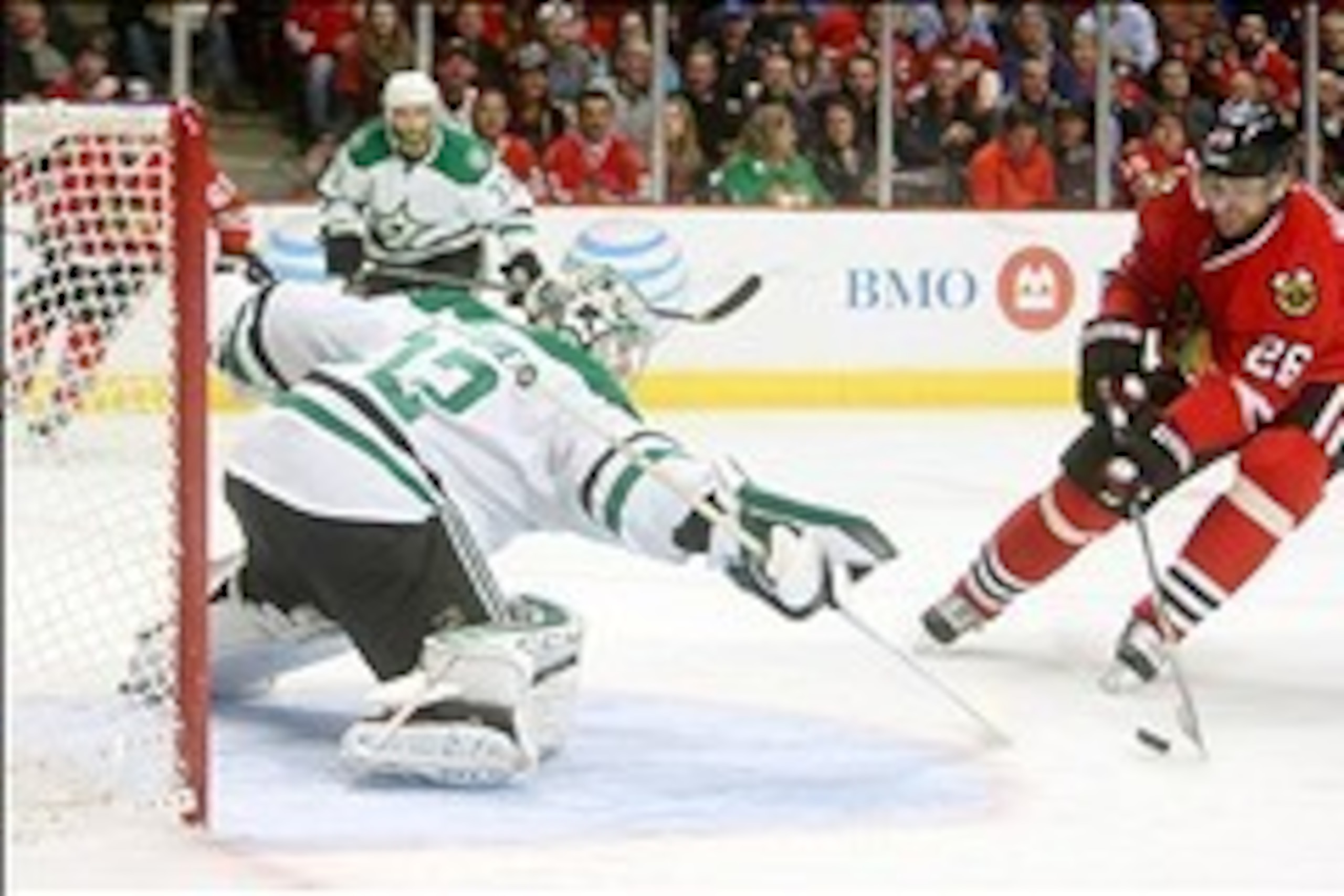 Mar 25, 2014; Chicago, IL, USA; Dallas Stars goalie Kari Lehtonen (32) knocks the puck off the stick of Chicago Blackhawks center Michal Handzus (26) during the second period at United Center. Mandatory Credit: Jerry Lai-USA TODAY Sports