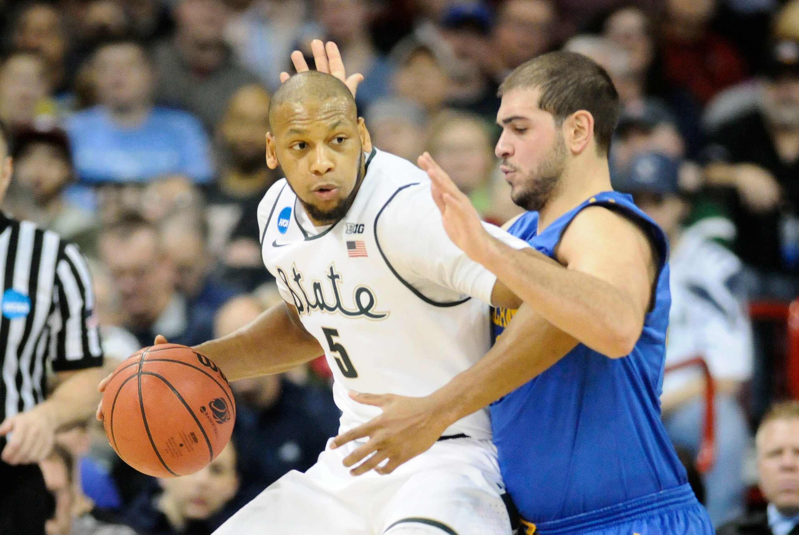 Mar 20, 2014; Spokane, WA, USA; Michigan State Spartans forward Adreian Payne (5) dribbles against Delaware Fightin Blue Hens forward Carl Baptiste (33) in the first half of a men's college basketball game during the second round of the 2014 NCAA Tourname