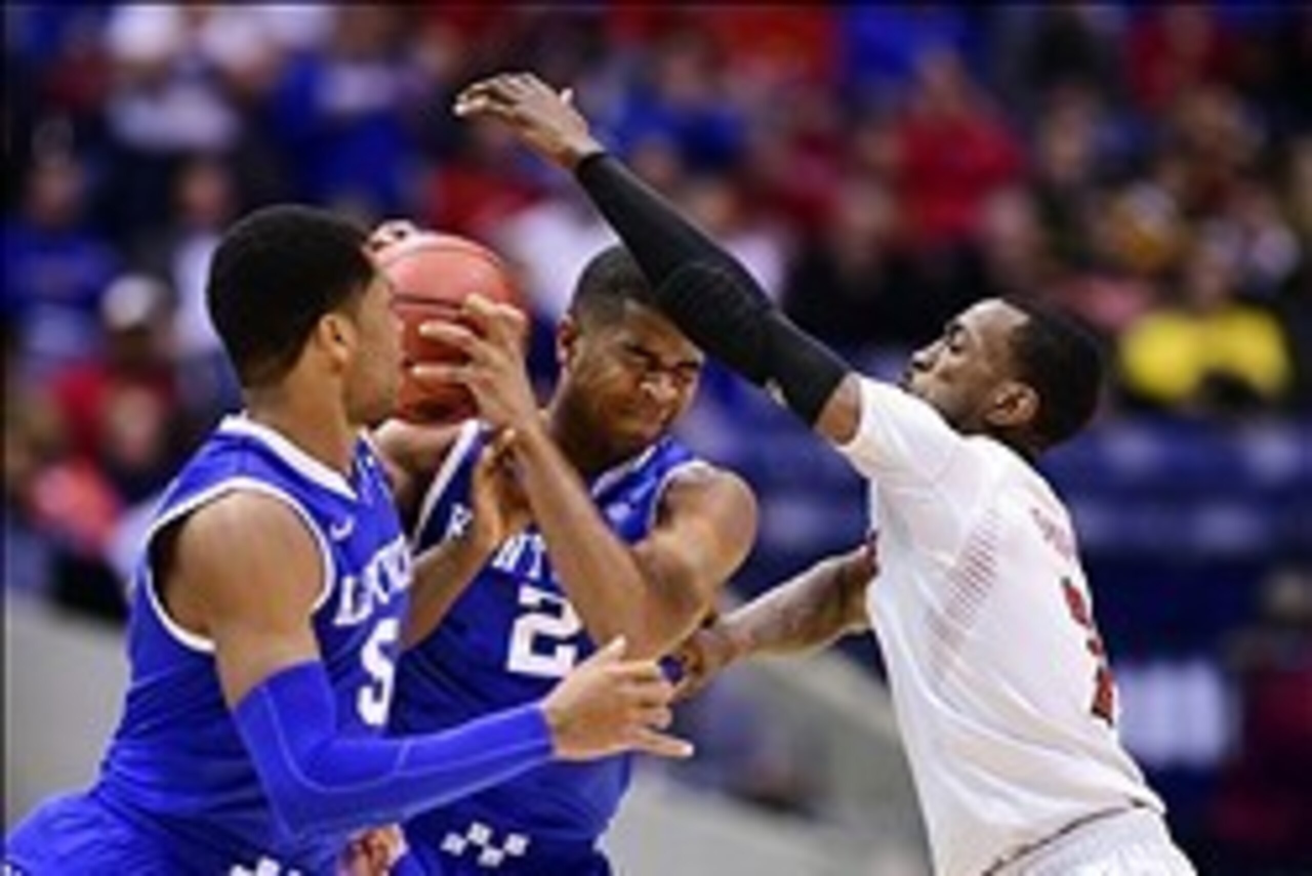 Mar 28, 2014; Indianapolis, IN, USA; Kentucky Wildcats guard Andrew Harrison (5) watches as guard Aaron Harrison (middle) is defended by Louisville Cardinals guard Russ Smith (right) in the second half in the semifinals of the midwest regional of the 2014