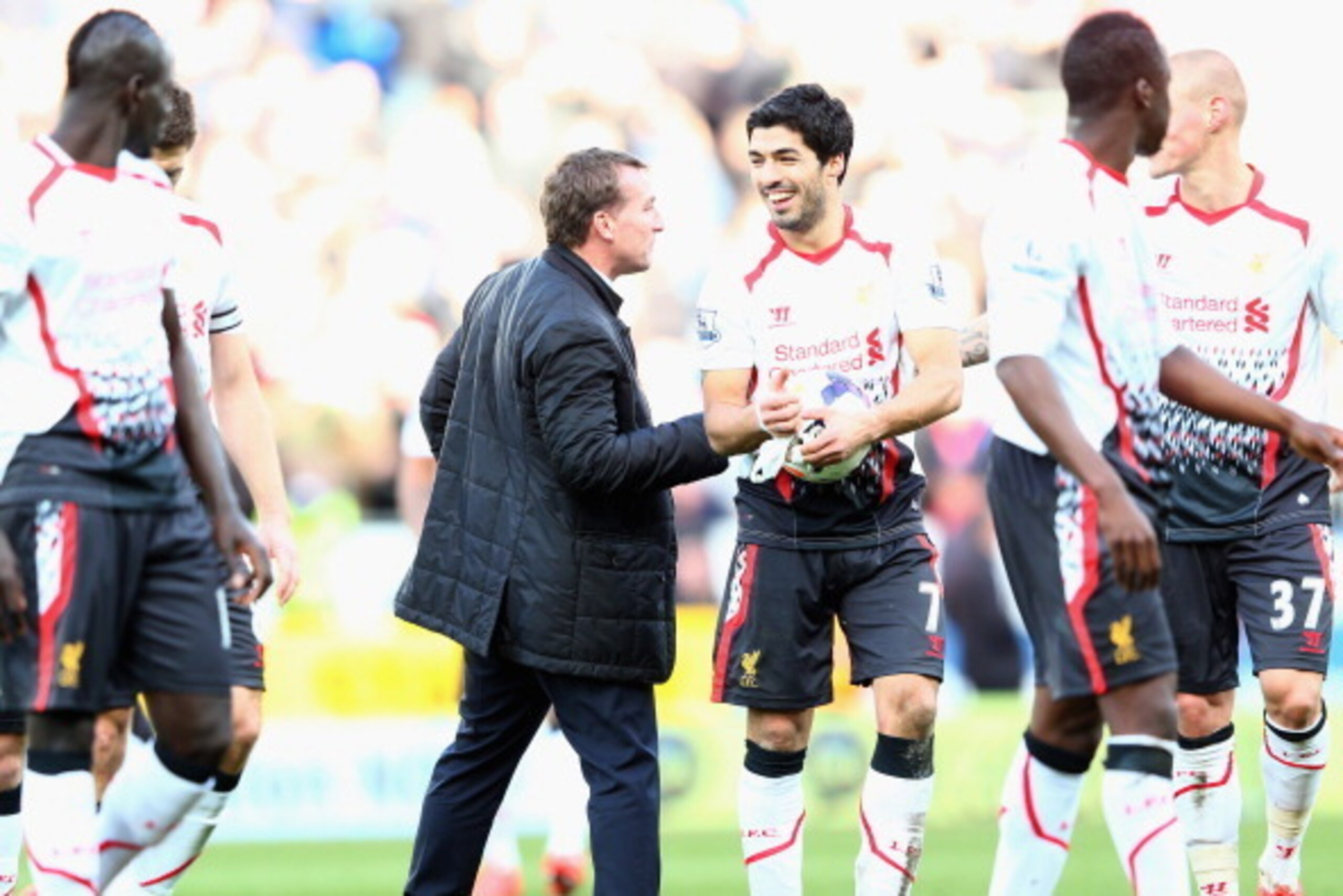 CARDIFF, WALES - MARCH 22:  Luis Suarez (3R) of Liverpool is congratulated by his manager Brendan Rodgers (L) at the final whistle after scoring a hat trick during his teams 6-3 victory during the Barclays Premier League match between Cardiff City and Liv