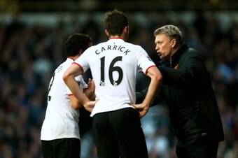 LONDON, ENGLAND - MARCH 22:  David Moyes the Manchester United manager speaks with Rafael and Michael Carrick of Manchester united during the Barclays Premier League match between West Ham United and Manchester United at Boleyn Ground on March 22, 2014 in