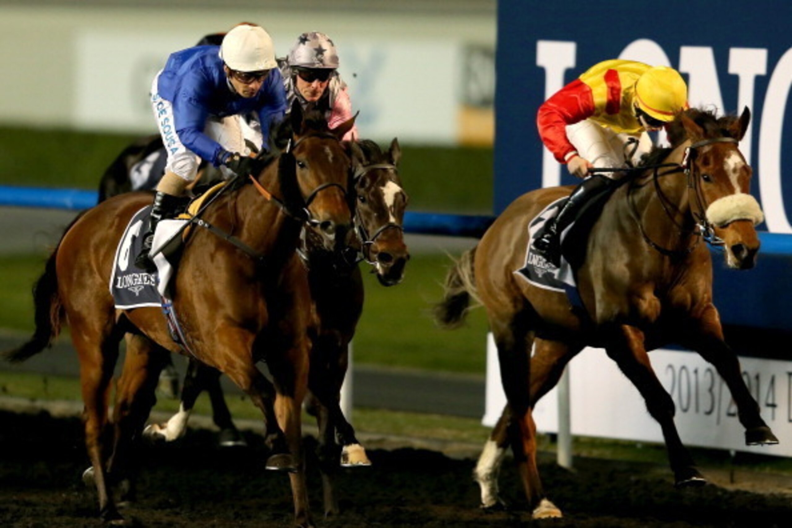 DUBAI, UNITED ARAB EMIRATES - JANUARY 09:  Silvestre De Sousa riding Shuruq (L) wins Race 6, Al Maktoum Challenge Round during the first Longines Carnival Meeting at the Meydan Racecourse on January 9, 2014 in Dubai, United Arab Emirates.  (Photo by Franc