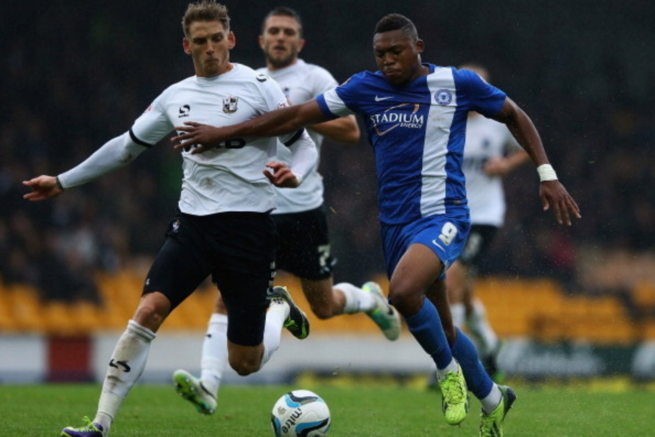 STOKE ON TRENT, ENGLAND - OCTOBER 12:  Daniel Jones of Port Vale and Britt Assombalonga of Peterborough United challenge for the ball during the Sky Bet League One match between Port Vale and Peterborough United at Vale Park on October 12, 2013 in Stoke o
