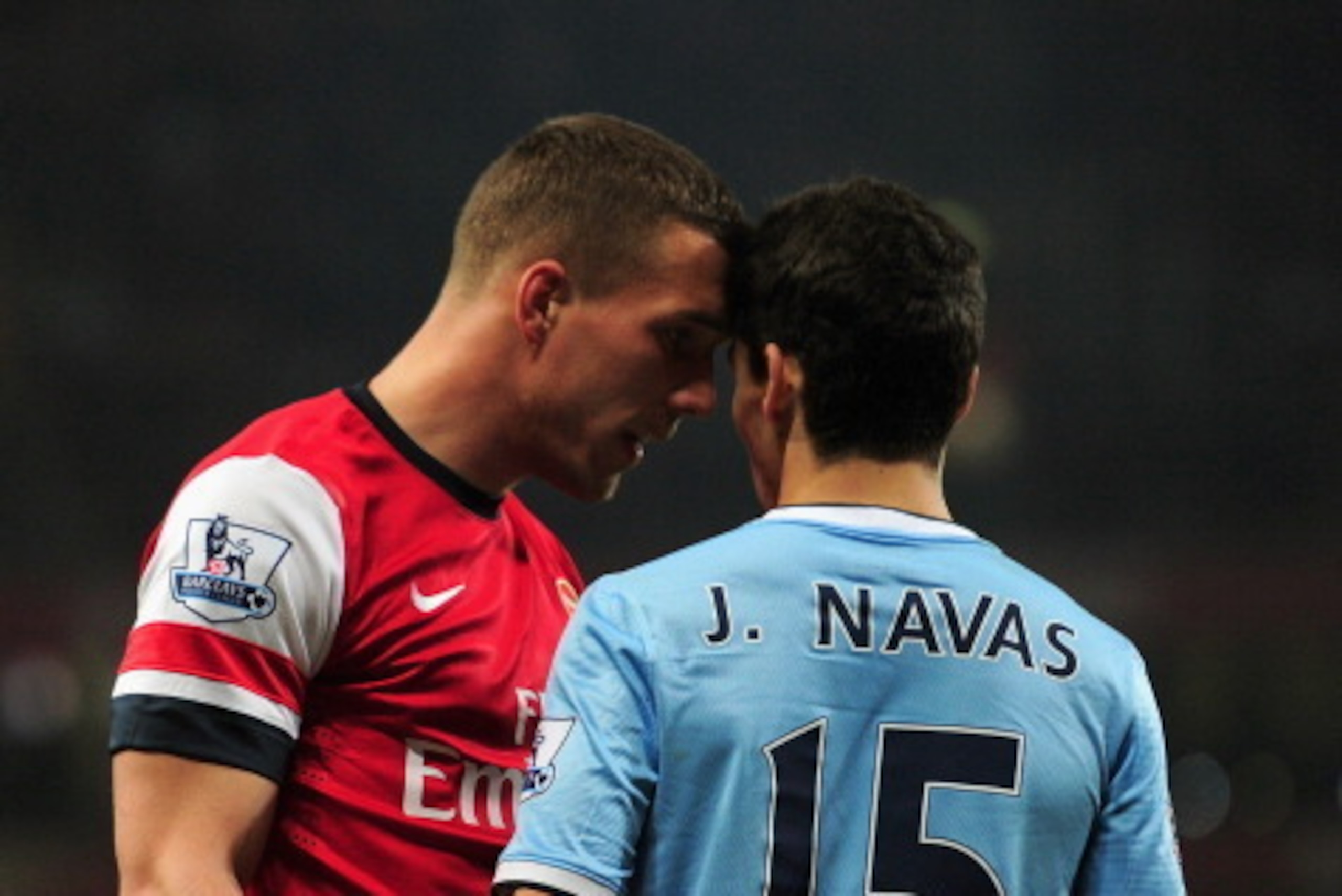 LONDON, ENGLAND - MARCH 29:  Lukas Podolski of Arsenal clashes with Jesus Navas of Manchester City during the Barclays Premier League match between Arsenal and Manchester City at Emirates Stadium on March 29, 2014 in London, England.  (Photo by Shaun Bott