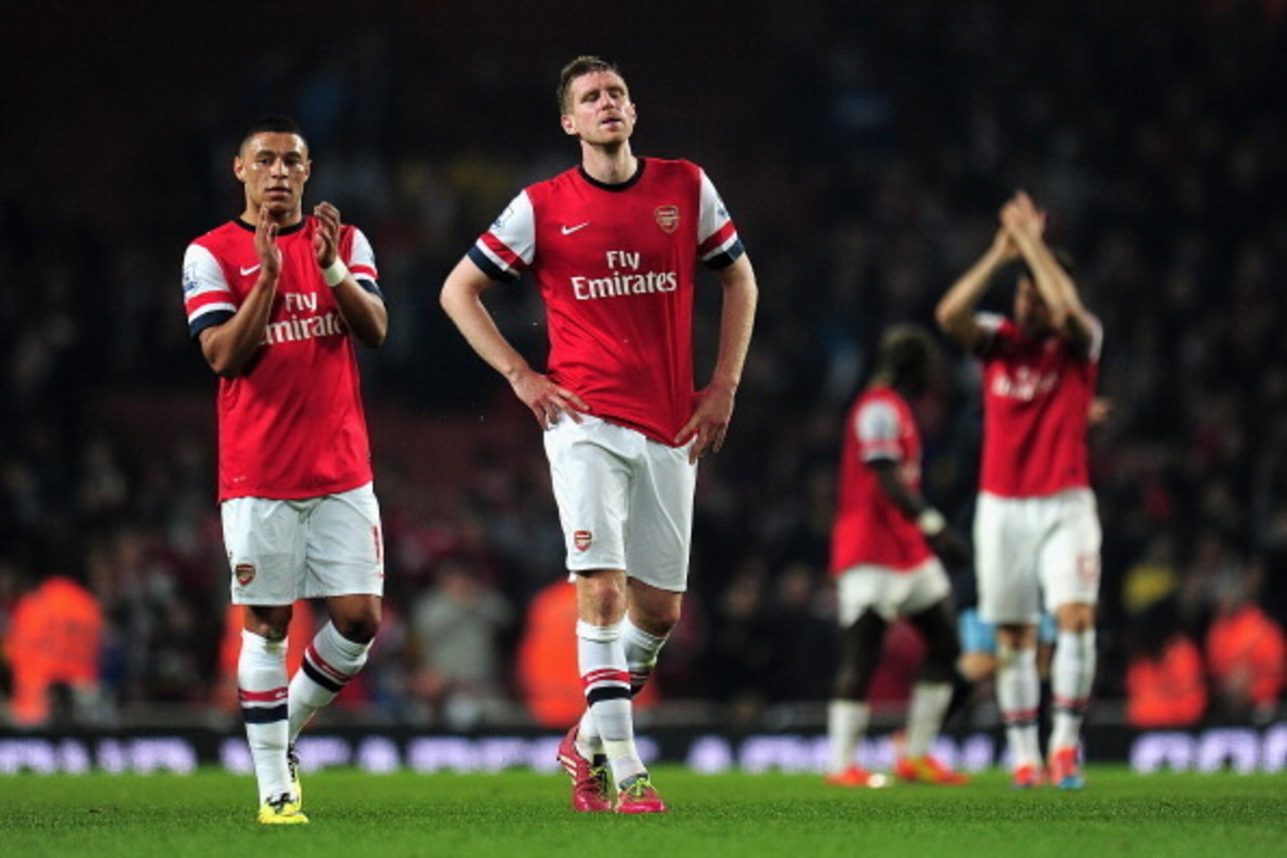 LONDON, ENGLAND - MARCH 29: Alex Oxlade-Chamberlain of Arsenal applauds the fans as Per Mertesacker of Arsenal looks on during the Barclays Premier League match between Arsenal and Manchester City at Emirates Stadium on March 29, 2014 in London, England. 