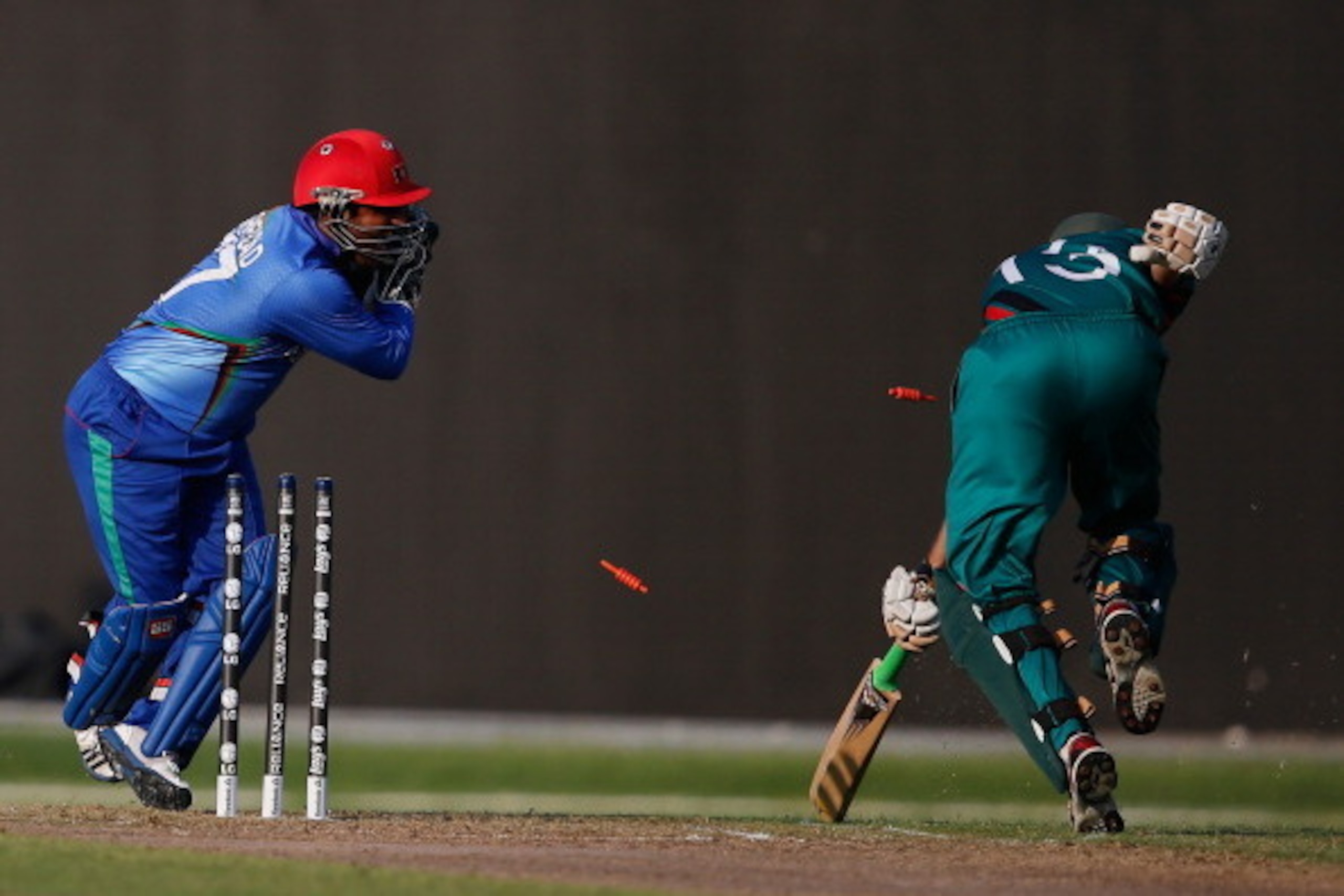 DUBAI, UNITED ARAB EMIRATES - NOVEMBER 24: Mohammad Shezad of Afghanistan attempts to run out Duncan Allan (R) of Kenya during the ICC World Twenty20 Qualifier between Afghanistan and Kenya at the Sharjah Cricket Stadium on November 24, 2013 in Dubai, Un DUBAI, UNITED ARAB EMIRATES - NOVEMBER 24: Mohammad Shezad of Afghanistan attempts to run out Duncan Allan (R) of Kenya during the ICC World Twenty20 Qualifier between Afghanistan and Kenya at the Sharjah Cricket Stadium on November 24, 2013 in Dubai, Un