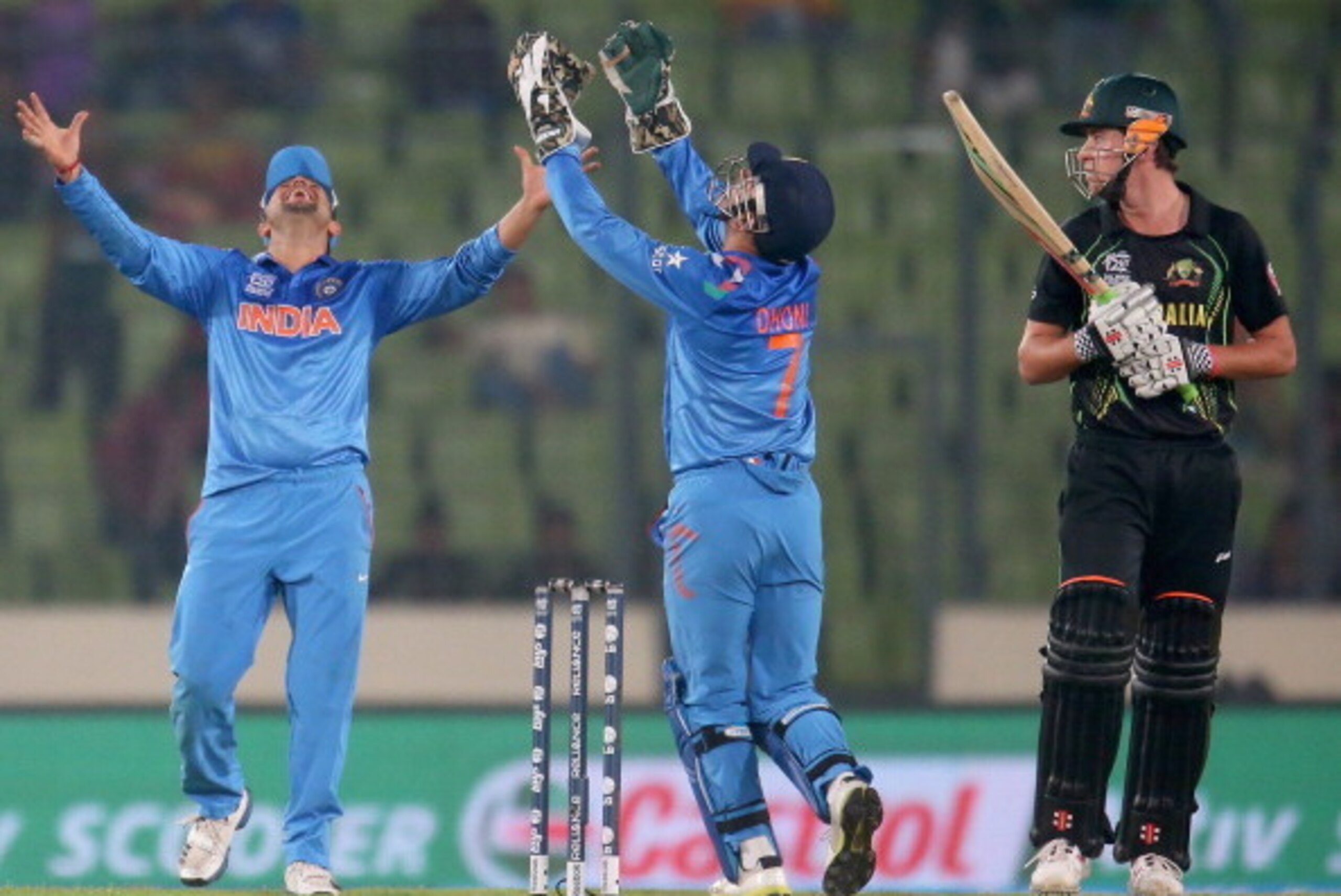 DHAKA, BANGLADESH - MARCH 30: James Muirhead of Australia looks on as MS Dhoni of India celebrates catching him out to win the match during the ICC World Twenty20 Bangladesh 2014 match between India v Australia at Sher-e-Bangla Mirpur Stadium on March 30 DHAKA, BANGLADESH - MARCH 30: James Muirhead of Australia looks on as MS Dhoni of India celebrates catching him out to win the match during the ICC World Twenty20 Bangladesh 2014 match between India v Australia at Sher-e-Bangla Mirpur Stadium on March 30