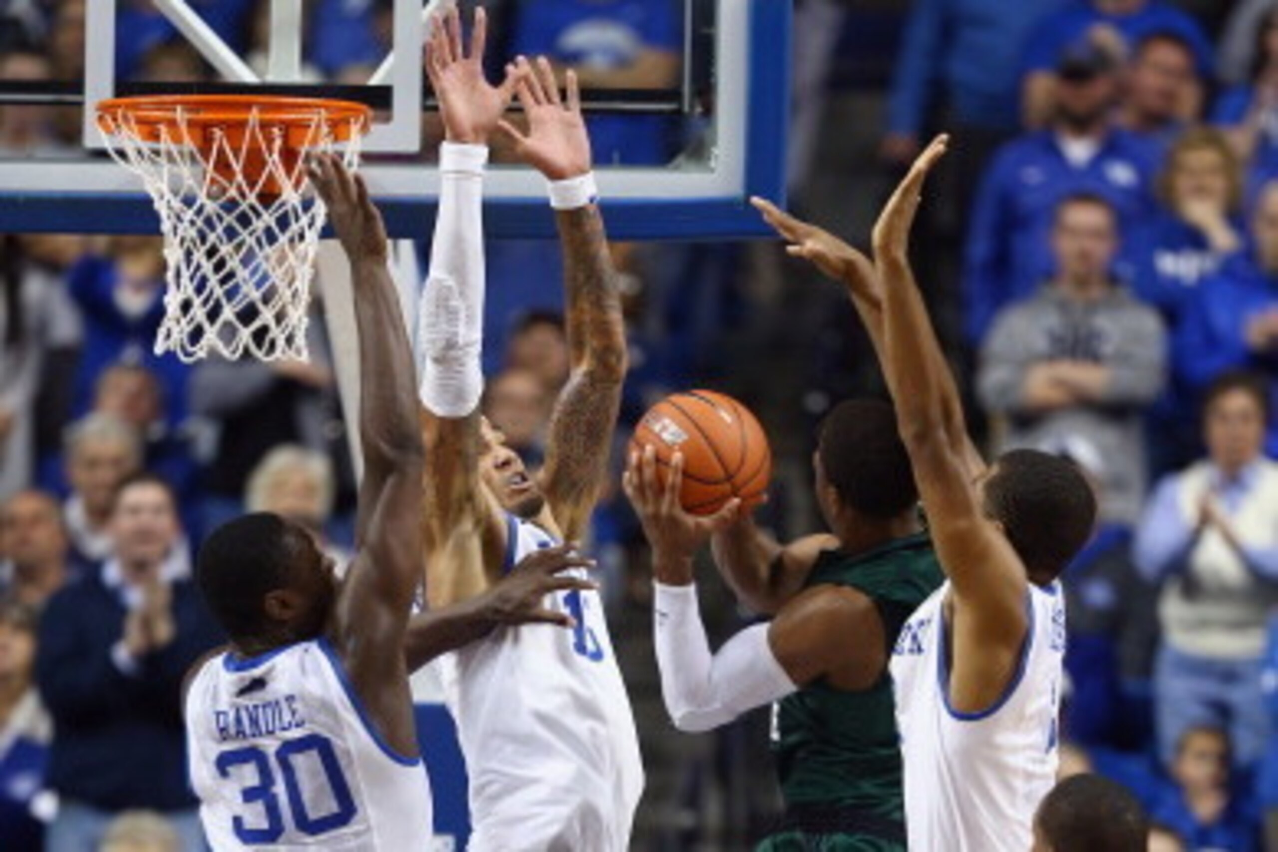 LEXINGTON, KY - NOVEMBER 25:  Julius Randle #30, Willie Cauley-Stein #15 and Andrew Harrison #5 of the Kentucky Wildcats defends the shot of Trey Lewis #3 of the Cleveland State Vikings during the game at Rupp Arena on November 25, 2013 in Lexington, Kent