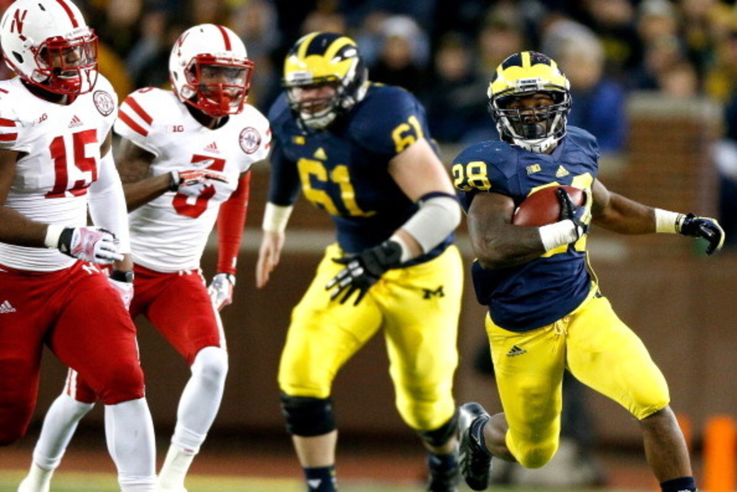 ANN ARBOR, MI - NOVEMBER 09:  Graham Glasgow #61 of the Michigan Wolverines blocks for Fitzgerald Toussaint #28 against Michael Rose #15 and Josh Mitchell #5 of the Nebraska Cornhuskers during the third quarter at Michigan Stadium on November 9, 2013 in A