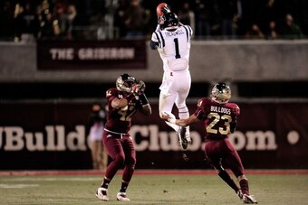 STARKVILLE, MS - NOVEMBER 28:  Laquon Treadwell #1 of the Ole Miss Rebels catches a pass between Beniquez Brown #42 and Taveze Calhoun #23 of the Mississippi State Bulldogs during a game at Davis Wade Stadium on November 28, 2013 in Starkville, Mississipp