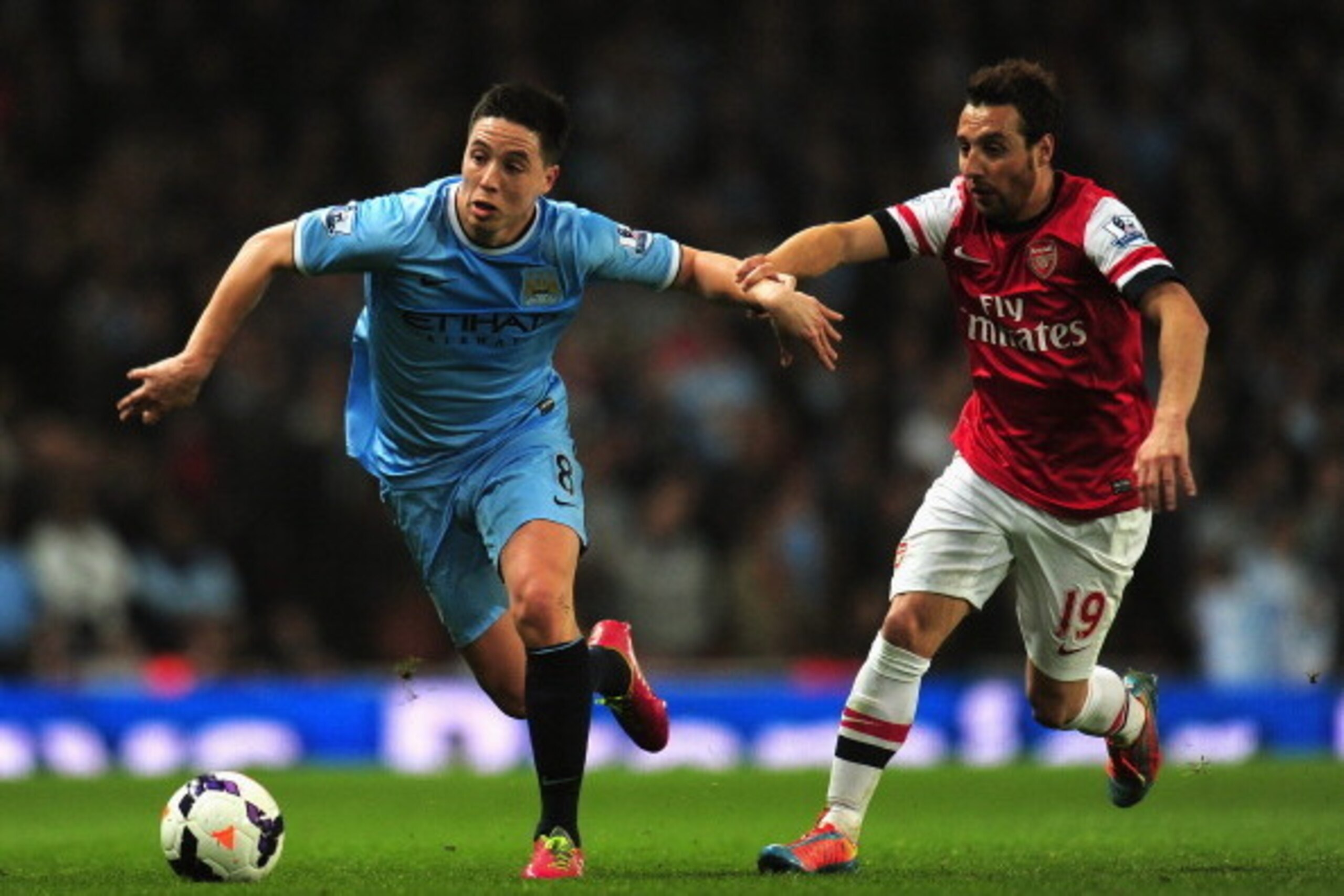 LONDON, ENGLAND - MARCH 29:  Samir Nasri of Manchester City and Santi Cazorla of Arsenal battle for the ball during the Barclays Premier League match between Arsenal and Manchester City at Emirates Stadium on March 29, 2014 in London, England.  (Photo by 