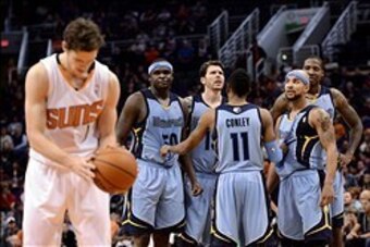 Jan 2, 2014; Phoenix, AZ, USA; Memphis Grizzlies guard Mike Conley (11) talks with teammates forward Zach Randolph (50), forward Mike Miller (13), guard Jerryd Bayless (7) and forward Ed Davis (32) as Phoenix Suns guard Goran Dragic (1) shoots a technical