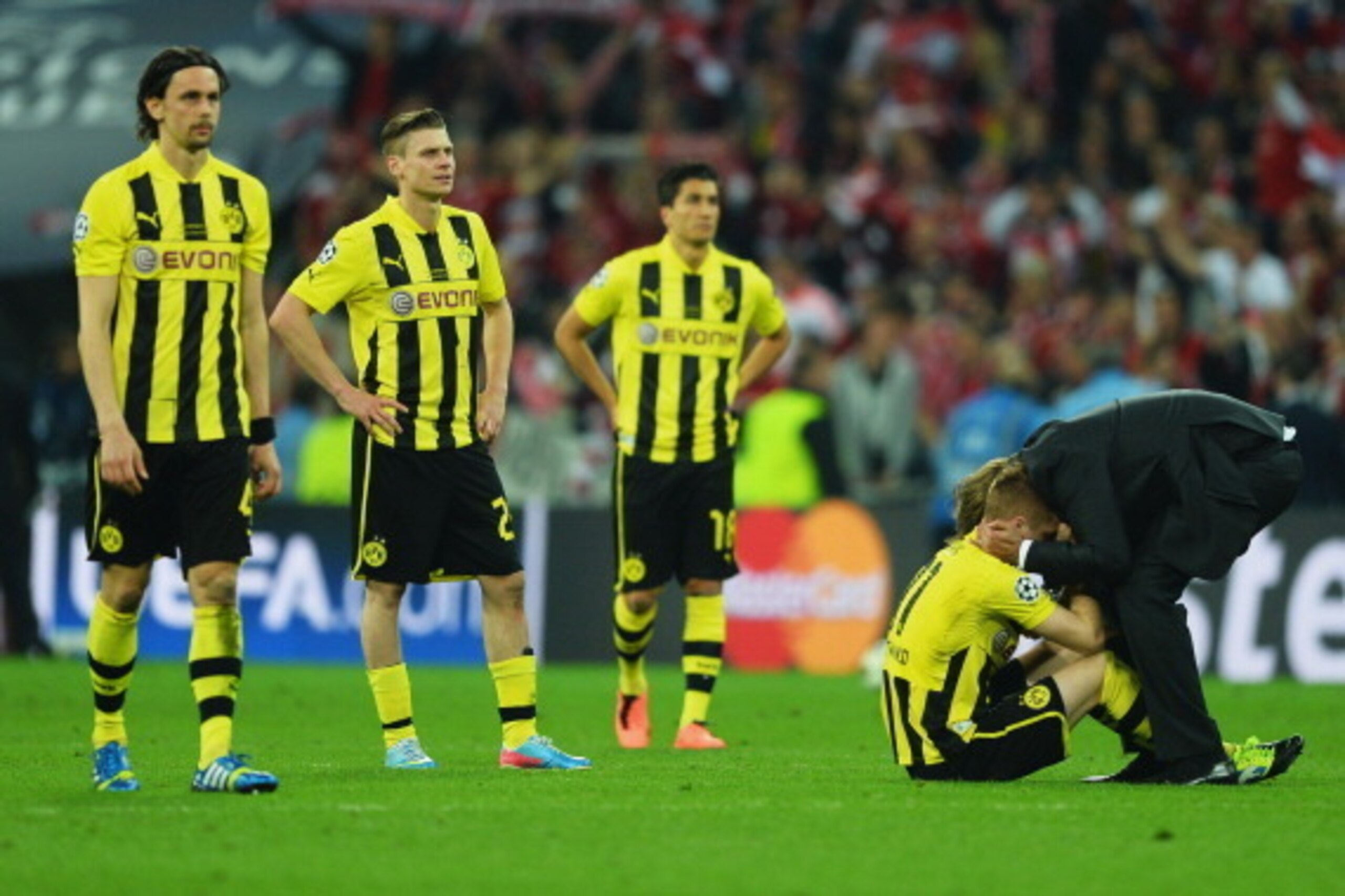 LONDON, ENGLAND - MAY 25:  (L-R) Neven Subotic, Lukasz Piszczek and Nuri Sahin of Borussia Dortmund look on as Marco Reus is consoled by Head Coach Jurgen Klopp of Borussia Dortmund in defeat after the UEFA Champions League final match between Borussia Do