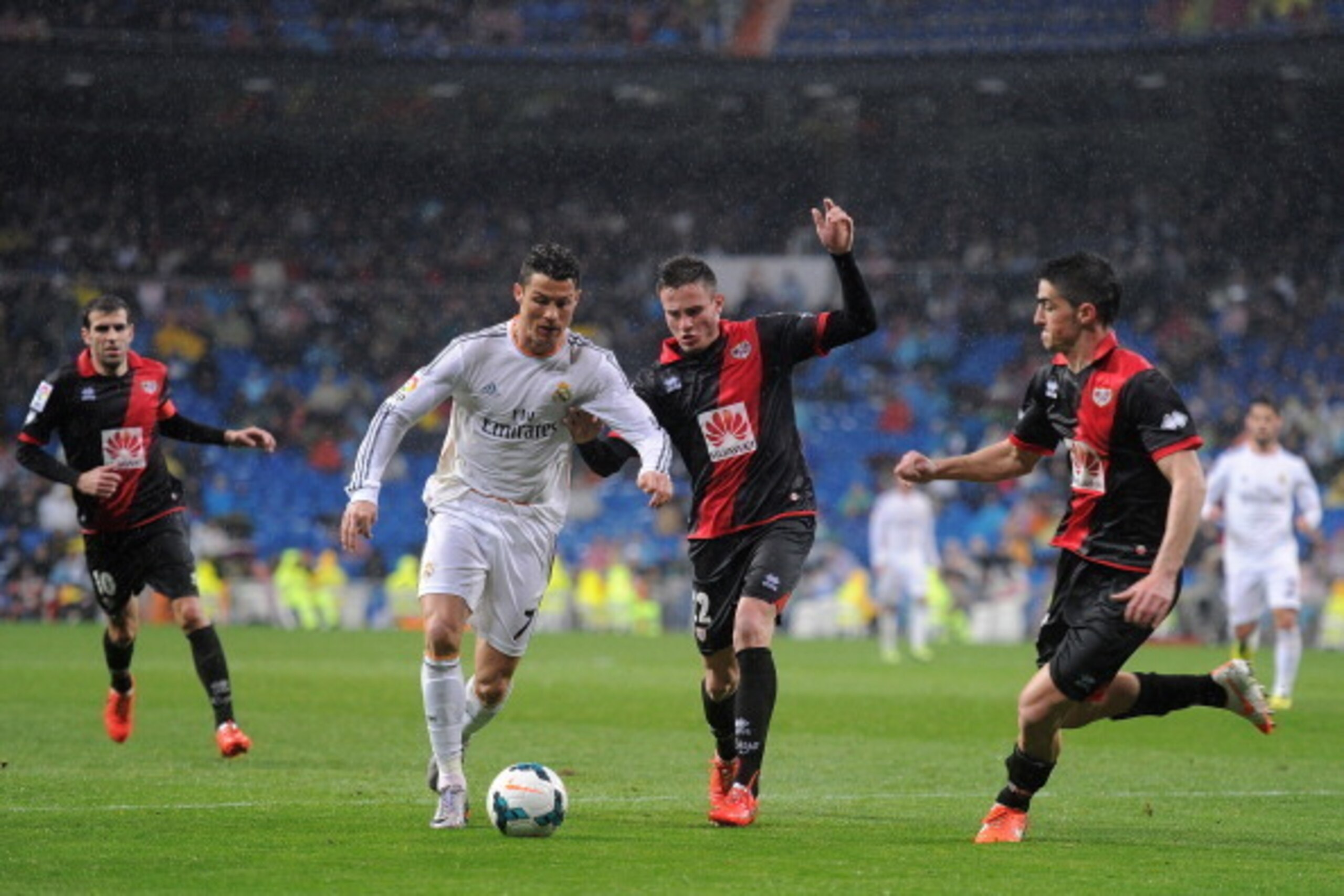 MADRID, SPAIN - MARCH 29:  Cristiano Ronaldo (L) of Real Madrid FC is tackled by Saul Niguez of Rayo Vallecano de Madrid during the La Liga match between Real Madrid CF and Rayo Vallecano de Madrid at Santiago Bernabeu stadium on March 29, 2014 in Madrid,