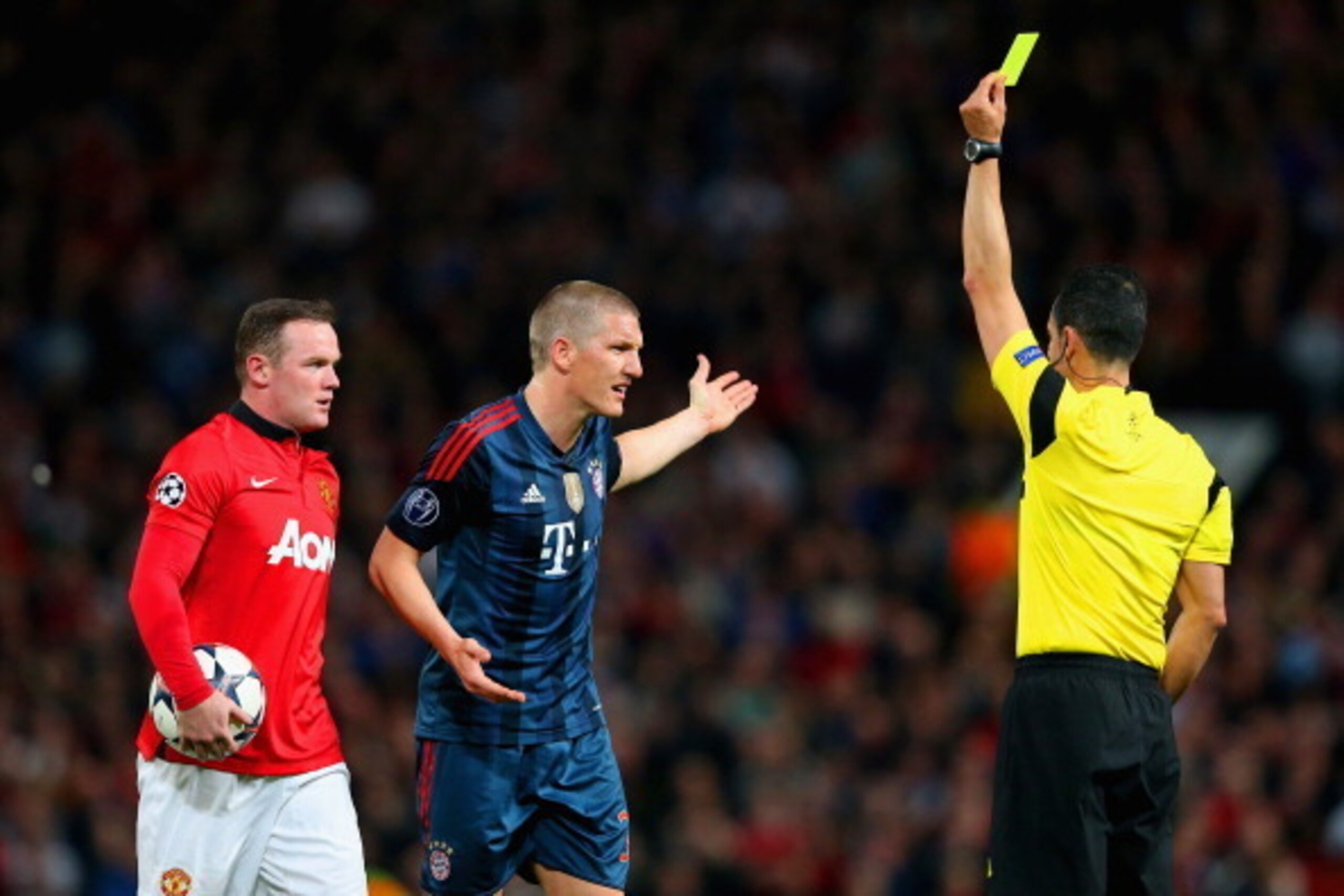 MANCHESTER, ENGLAND - APRIL 01:  Wayne Rooney of Manchester United looks on as Bastian Schweinsteiger of Bayern Muenchen receives his first yellow card from Referee Carlos Velasco Carballo during the UEFA Champions League Quarter Final first leg match bet