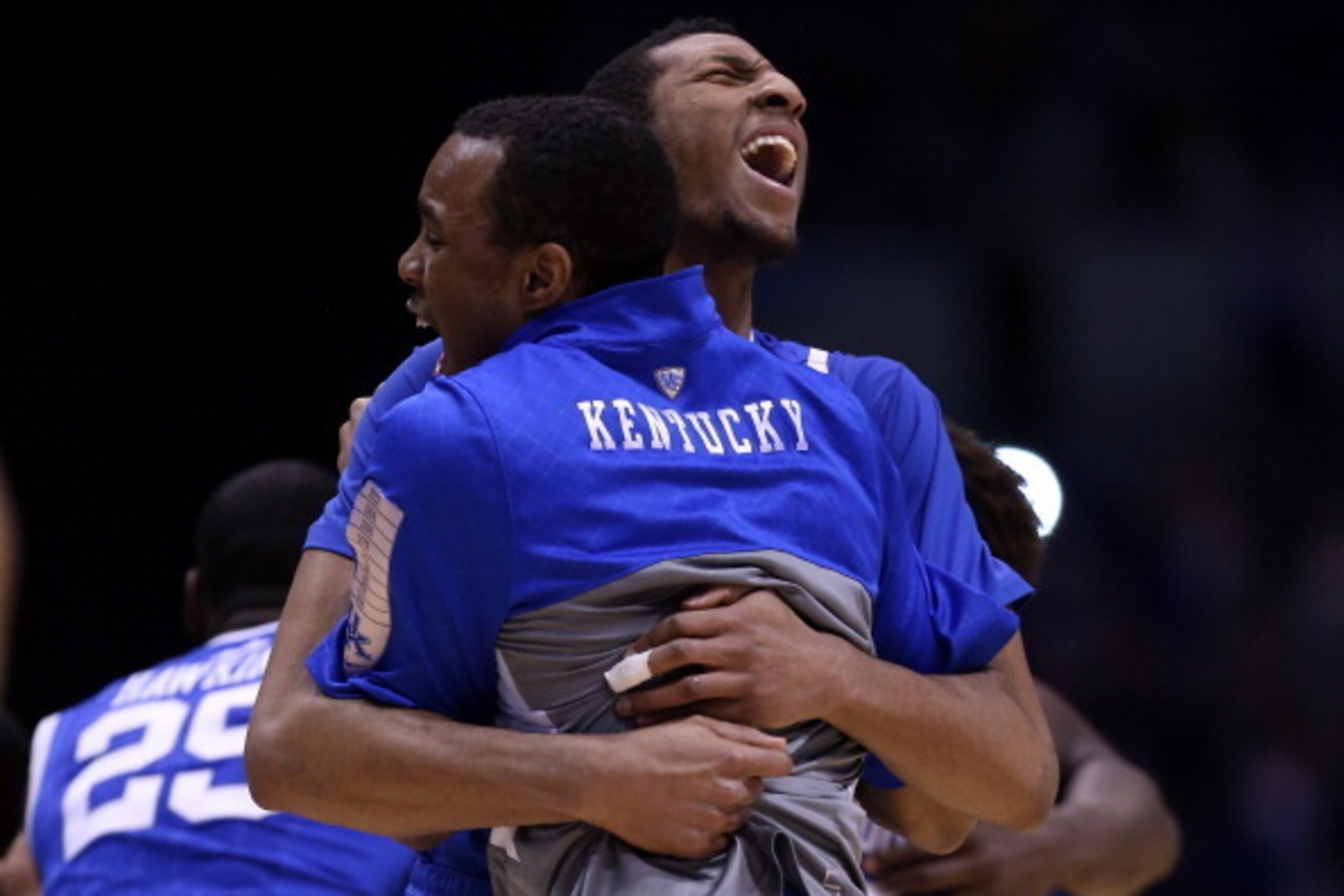 INDIANAPOLIS, IN - MARCH 30:  Marcus Lee #00 of the Kentucky Wildcats celebrates with his teammate after defeating the Michigan Wolverines 75 to 72 in the midwest regional final of the 2014 NCAA Men's Basketball Tournament at Lucas Oil Stadium on March 30