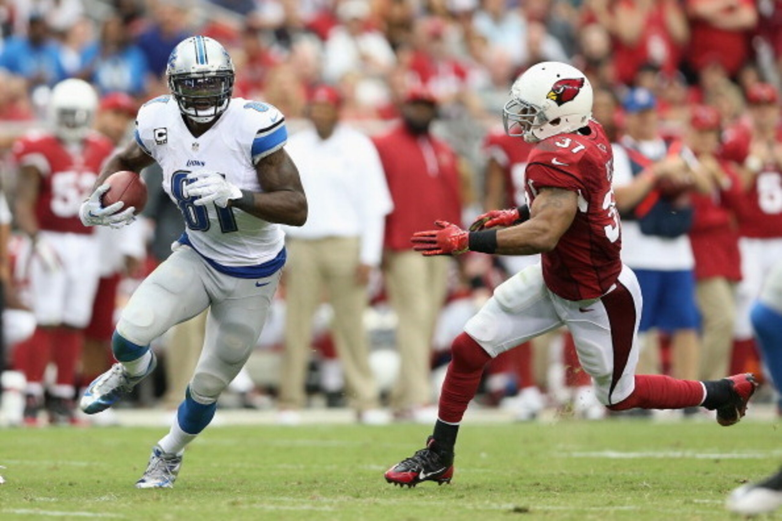 GLENDALE, AZ - SEPTEMBER 15:  Wide receiver Calvin Johnson #81 of the Detroit Lions runs with the football after a reception past strong safety Yeremiah Bell #37 of the Arizona Cardinals during the NFL game at the University of Phoenix Stadium on Septembe