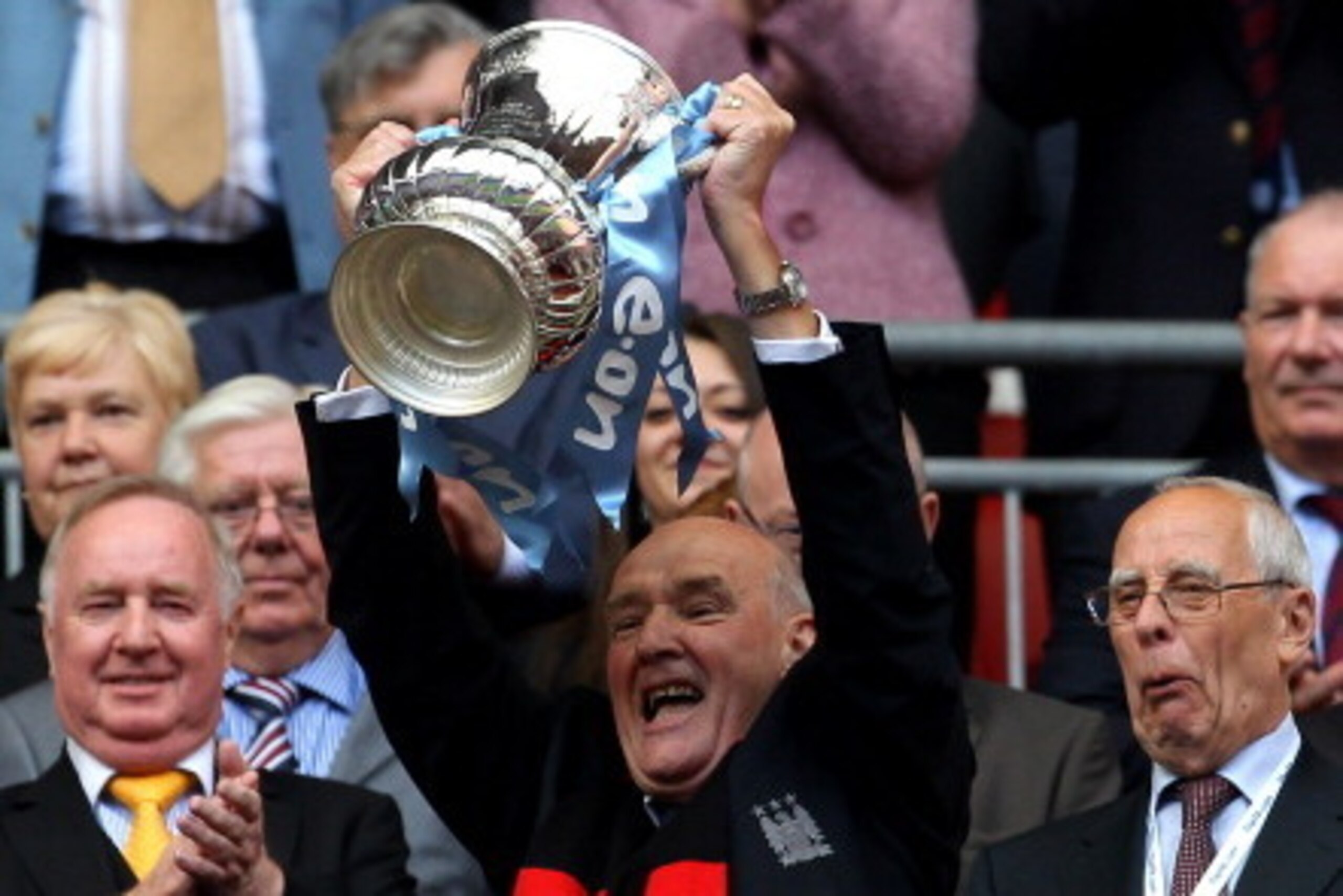 LONDON, ENGLAND - MAY 14:  Manchester City Life President Bernard Halford lifts the trophy after his Manchester City team won the FA Cup sponsored by E.ON Final match between Manchester City and Stoke City at Wembley Stadium on May 14, 2011 in London, Eng