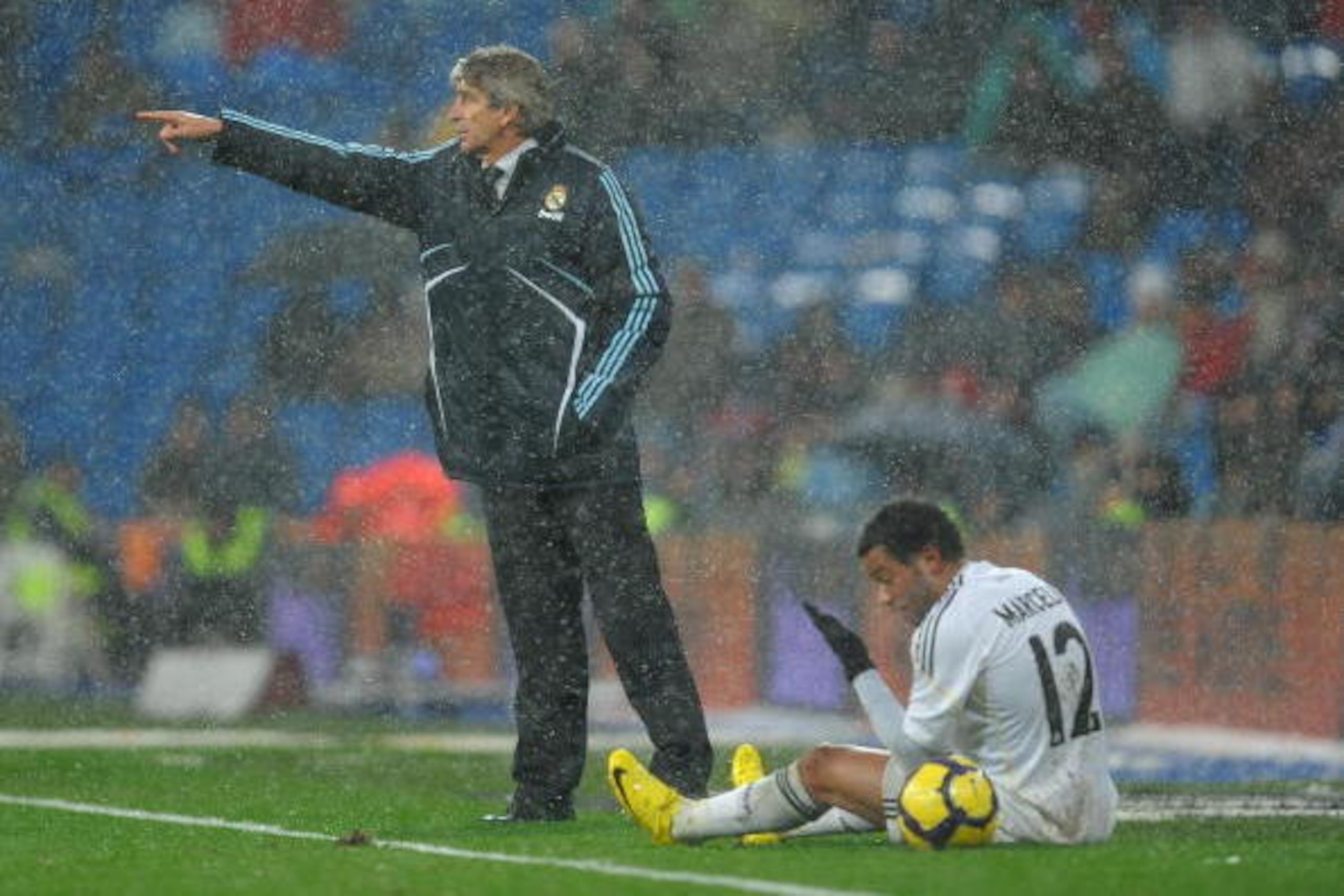 MADRID, SPAIN - JANUARY 10:  Head coach Manuel Pellegrini of Real Madrid reacts to his players as Marcelo Vieira sits on the pitch during the La Liga match between Real Madrid and Mallorca at the Estadio Santiago Bernabeu on January 10, 2010 in Madrid, Sp
