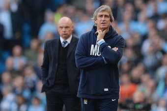 MANCHESTER, ENGLAND - MARCH 09: Wigan manager Uwe Rosler and Man City manager Manuel Pellegrini look on during the FA Cup Quarter-Final match between Manchester City and Wigan Athletic at the Etihad Stadium on March 9, 2014 in Manchester, England.  (Photo