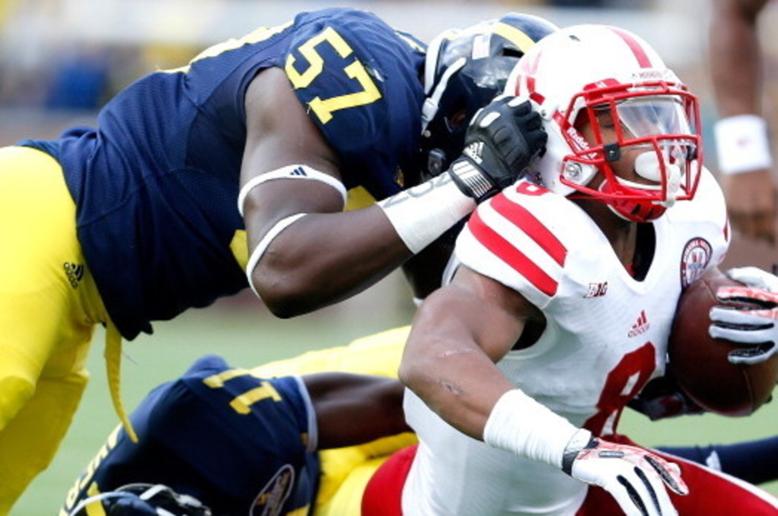 ANN ARBOR, MI - NOVEMBER 09:  Frank Clark #57 of the Michigan Wolverines drags down Ameer Abdullah #8 of the Nebraska Cornhuskers in the first half at Michigan Stadium on November 9, 2013 in Ann Arbor, Michigan.  (Photo by Gregory Shamus/Getty Images)