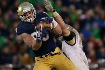 SOUTH BEND, IN - NOVEMBER 02: Troy Niklas #85 of the Notre Dame Fighting Irish catches a first down pass in front of Cody Peterson #53 of the Navy Midshipmen at Notre Dame Stadium on November 2, 2013 in South Bend, Indiana. Notre Dame defeated Navy 38-34.