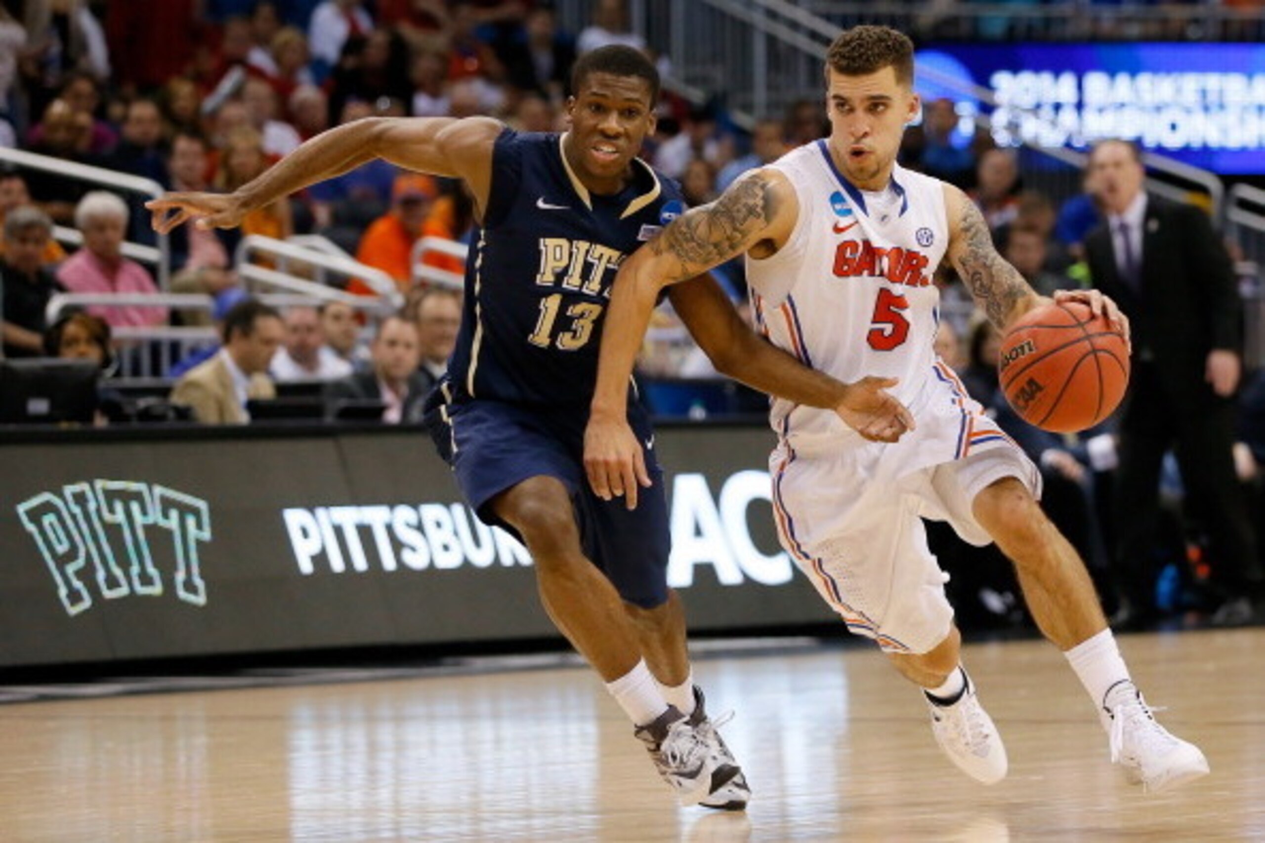 ORLANDO, FL - MARCH 22:  Scottie Wilbekin #5 of the Florida Gators drives on Josh Newkirk #13 of the Pittsburgh Panthers in the second half during the third round of the 2014 NCAA Men's Basketball Tournament at Amway Center on March 22, 2014 in Orlando, F