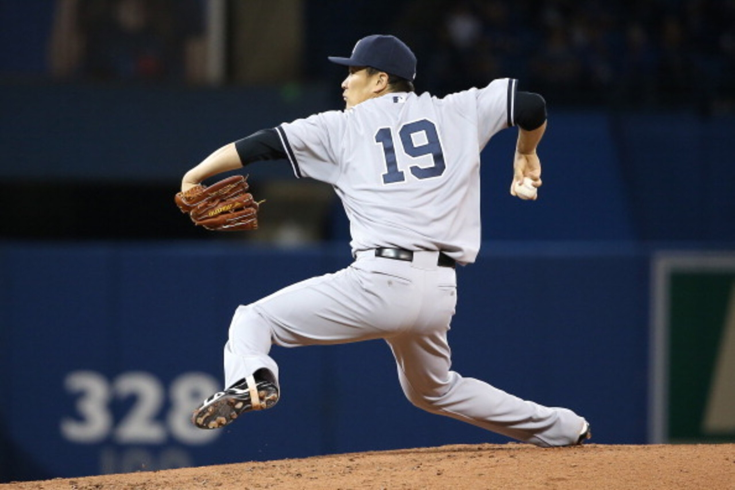 TORONTO, CANADA - APRIL 4: Masahiro Tanaka #19 of the New York Yankees delivers a pitch in the second inning during MLB game action against the Toronto Blue Jays on April 4, 2014 at Rogers Centre in Toronto, Ontario, Canada. (Photo by Tom Szczerbowski/Get