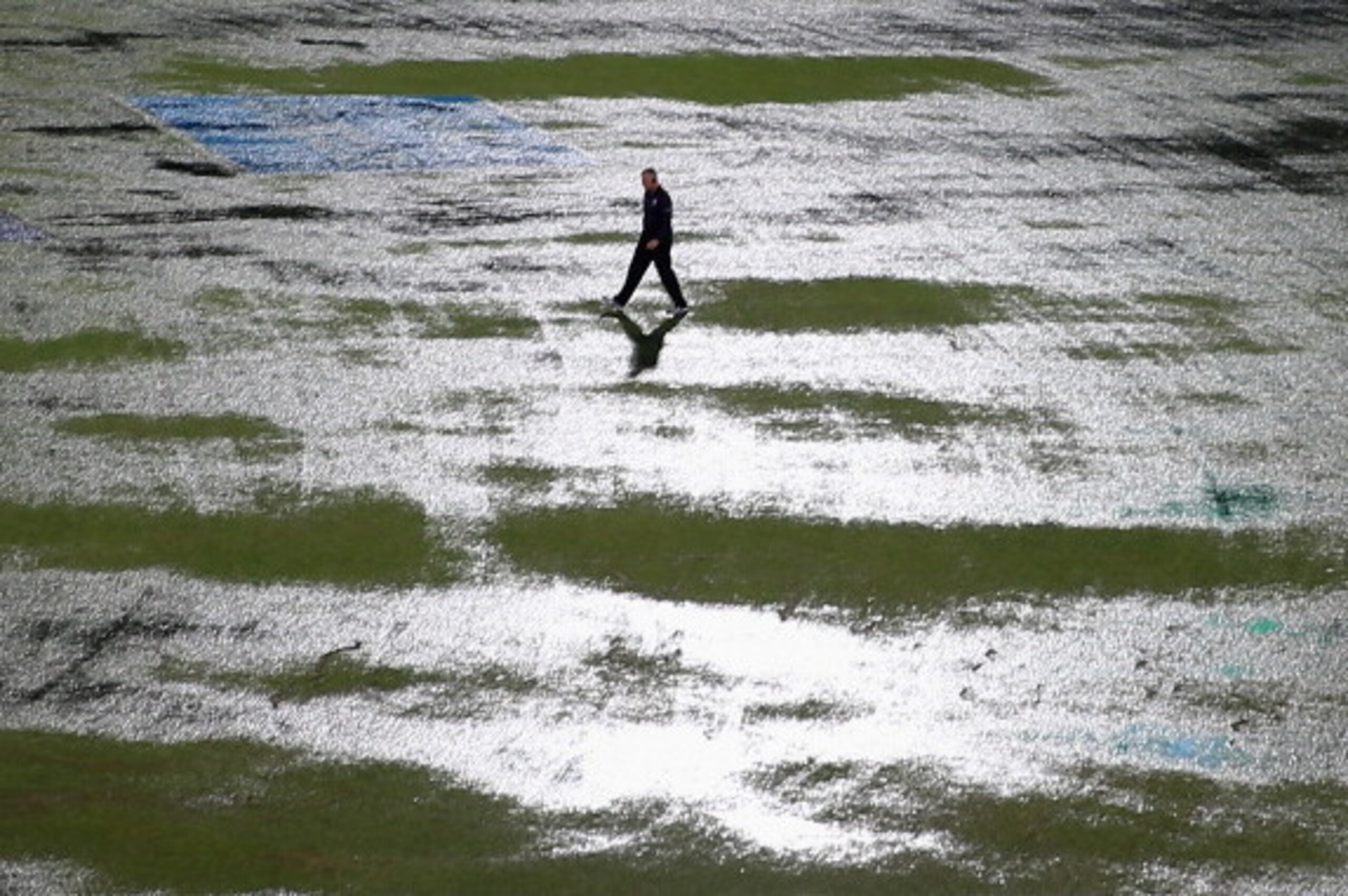 DHAKA, BANGLADESH - APRIL 03: An umpire walks out to inspect the flooded field after heavy rain drenched the ground during the ICC World Twenty20 Bangladesh 2014 1st Semi-Final match between Sri Lanka and the West Indies at Sher-e-Bangla Mirpur Stadium o DHAKA, BANGLADESH - APRIL 03: An umpire walks out to inspect the flooded field after heavy rain drenched the ground during the ICC World Twenty20 Bangladesh 2014 1st Semi-Final match between Sri Lanka and the West Indies at Sher-e-Bangla Mirpur Stadium o