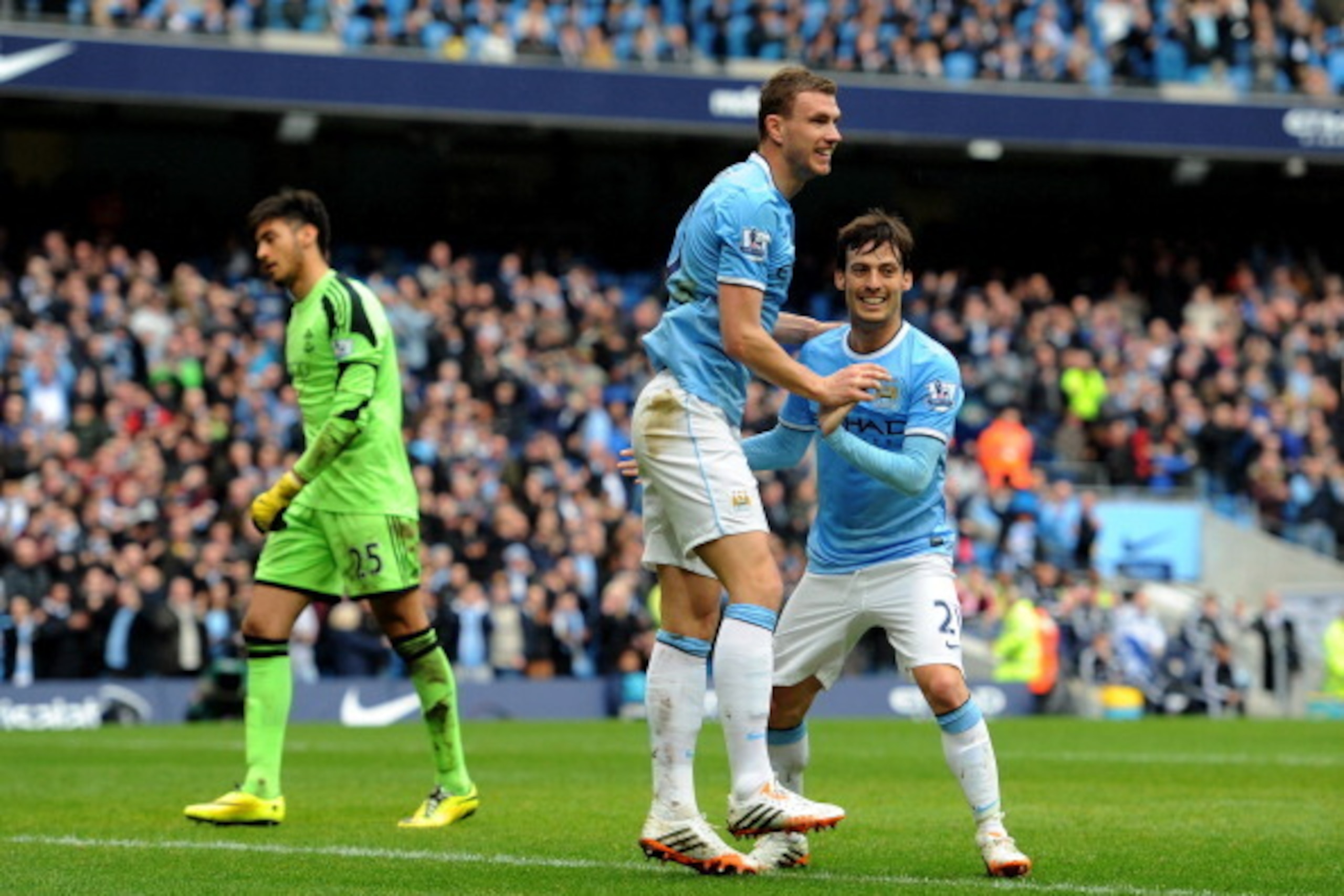 MANCHESTER, ENGLAND - APRIL 05:  Edin Dzeko (C) of Manchester City is congratulated by teammate David Silva (R) after scoring his team's third goal as dejected goalkeeper Paulo Gazzaniga of Southampton looks on during the Barclays Premier League match bet