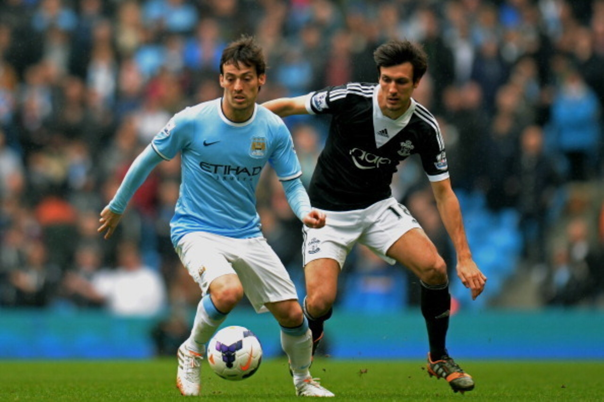 MANCHESTER, ENGLAND - APRIL 05:  David Silva of Manchester City is challenged by Jack Cork of Southampton during the Barclays Premier League match between Manchester City and Southampton at Etihad Stadium on April 5, 2014 in Manchester, England.  (Photo b