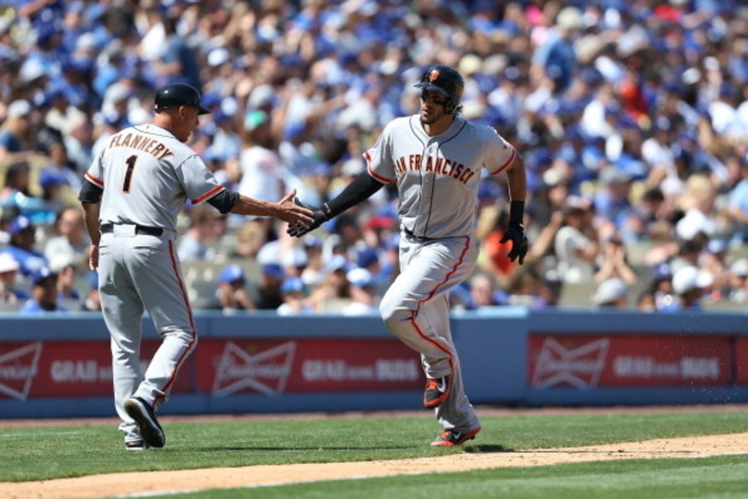 LOS ANGELES, CA - APRIL 05: Michael Morse #38 of the San Francisco Giants celebrates with a hand slap with third base coach Tim Flannery #1 as Morse rounds third base after hitting a solo home run in the fourth inning during the MLB game against the Los A