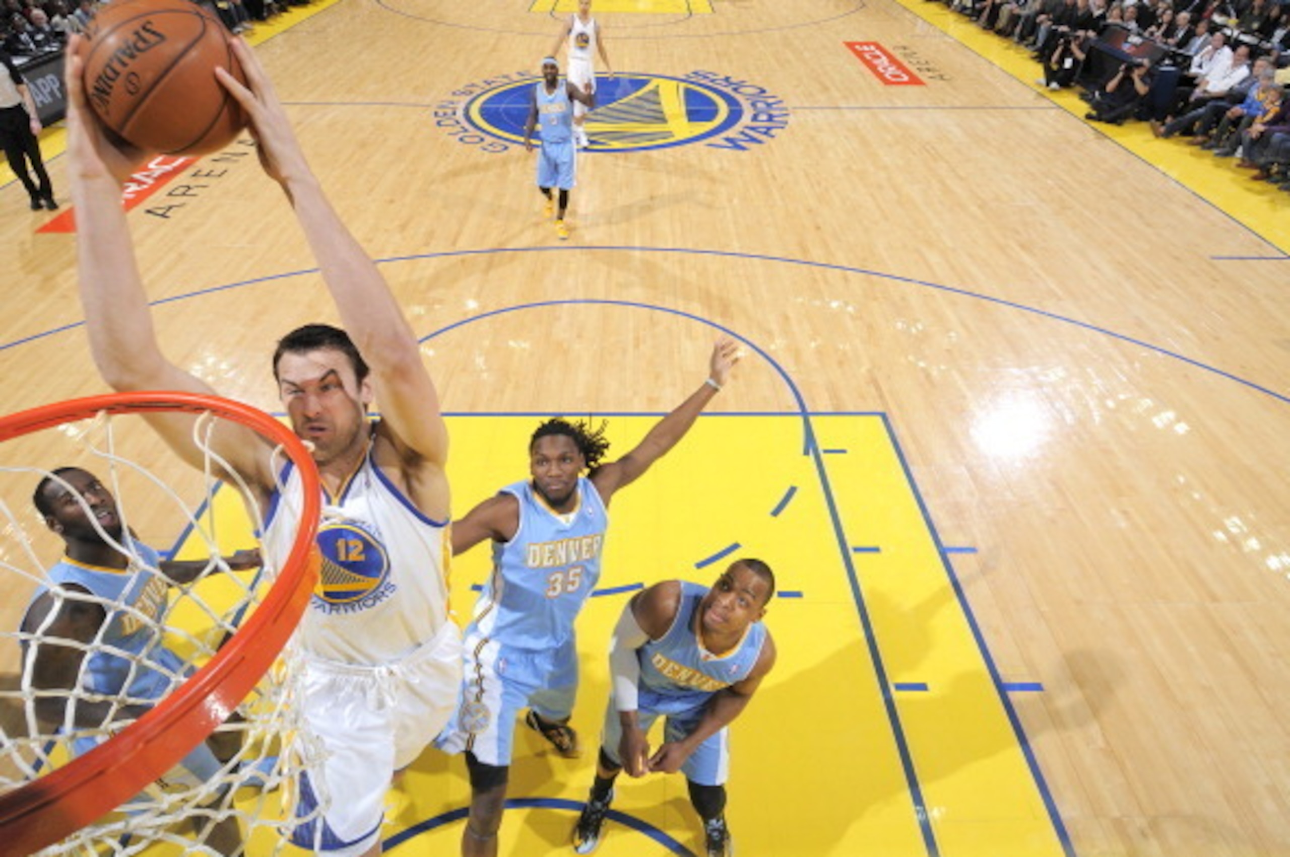 OAKLAND, CA - JANUARY 15: Andrew Bogut #12 of the Golden State Warriors dunks against the Denver Nuggets on January 15, 2014 at Oracle Arena in Oakland, California. NOTE TO USER: User expressly acknowledges and agrees that, by downloading and or using thi