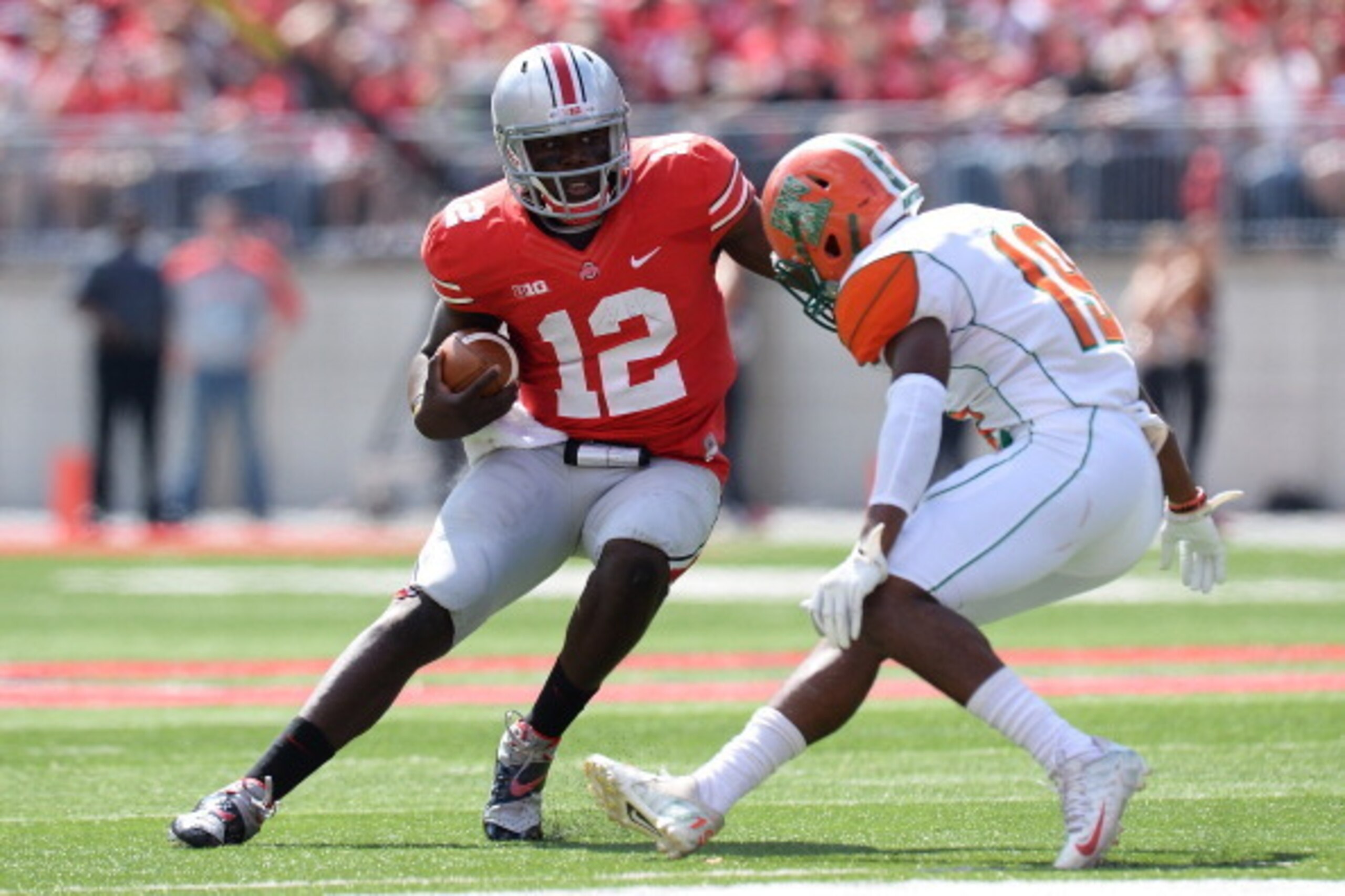 COLUMBUS, OH - SEPTEMBER 21:  Quarterback Cardale Jones #12 of the Ohio State Buckeyes sidesteps Jonathan Pillow #19 of the Florida A&M Rattlers in the third quarter as he picks up yardage at Ohio Stadium on September 21, 2013 in Columbus, Ohio. Ohio Stat