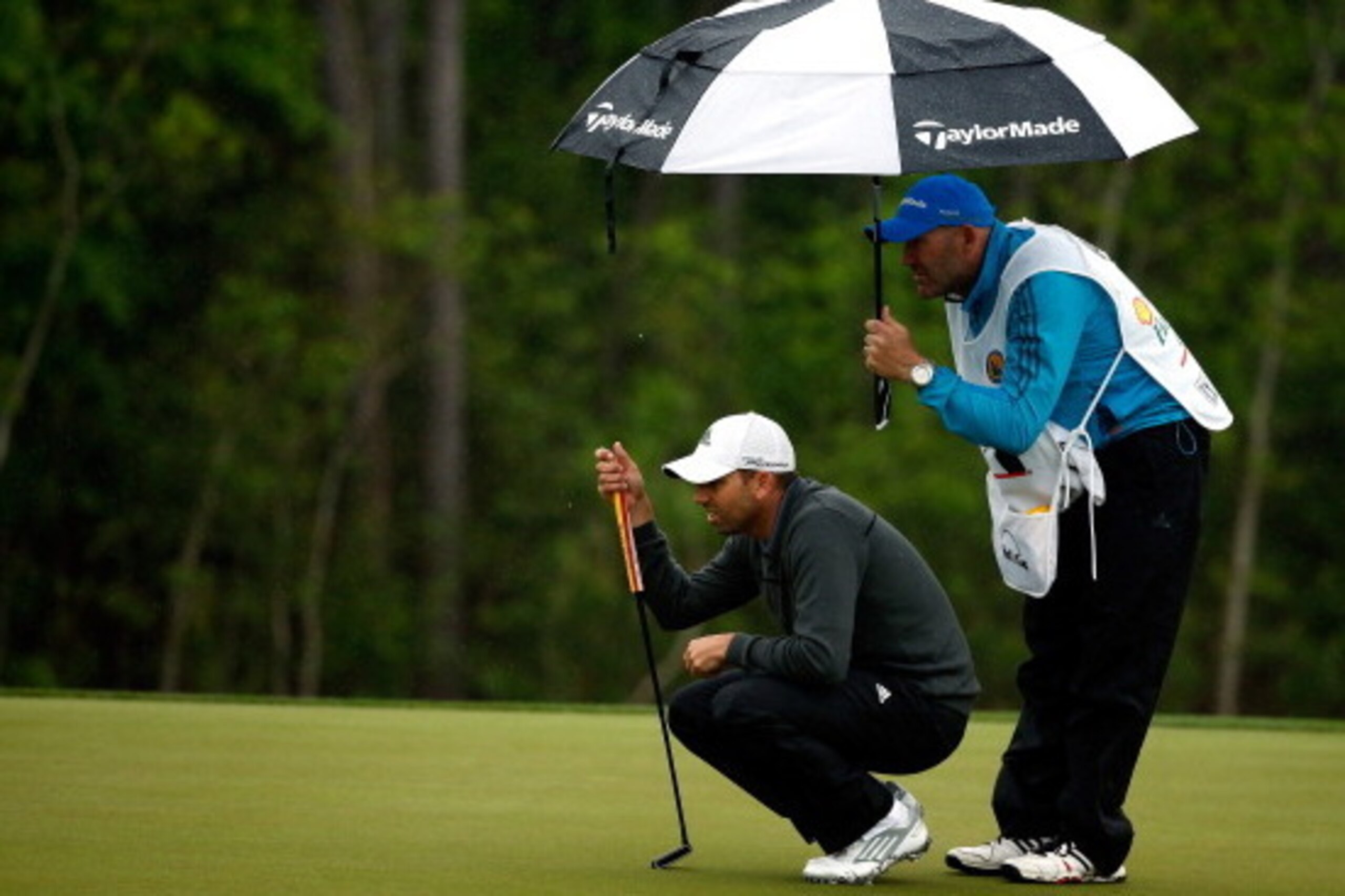 HUMBLE, TX - APRIL 06: Sergio Garcia of Spain lines up a shot on the green of as his caddy Neil Wallace holds his umbrella on the eighth hole during the final round of the Shell Houston Open at the Golf Club of Houston on April 6, 2014 in Humble, Texas. HUMBLE, TX - APRIL 06: Sergio Garcia of Spain lines up a shot on the green of as his caddy Neil Wallace holds his umbrella on the eighth hole during the final round of the Shell Houston Open at the Golf Club of Houston on April 6, 2014 in Humble, Texas.