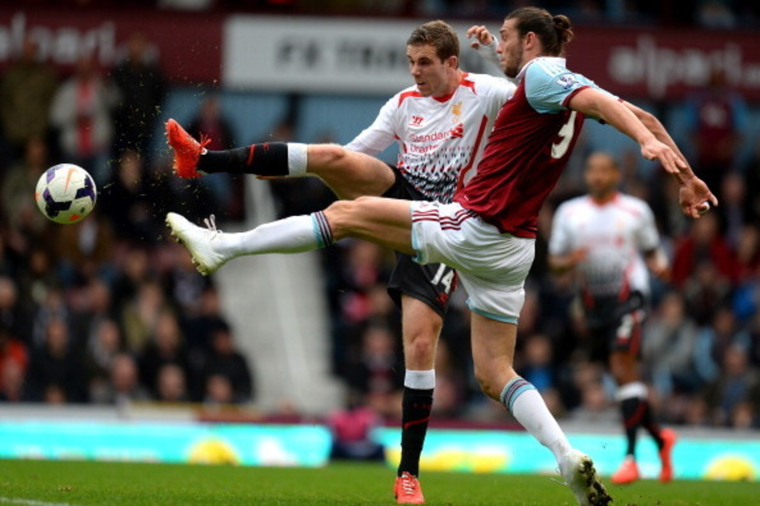 LONDON, ENGLAND - APRIL 06:  Jordan Henderson of Liverpool and Andy Carroll of West Ham compete for the ball during the Barclays Premier League match between West Ham United and Liverpool at Boleyn Ground on April 6, 2014 in London, England.  (Photo by Mi