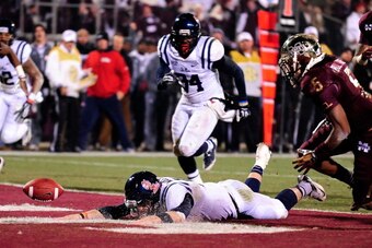 STARKVILLE, MS - NOVEMBER 28:  Bo Wallace #14 of the Ole Miss Rebels fumbles the football during a game against the Mississippi State Bulldogs at Davis Wade Stadium on November 28, 2013 in Starkville, Mississippi.  Mississippi State won the game 17-10.  (