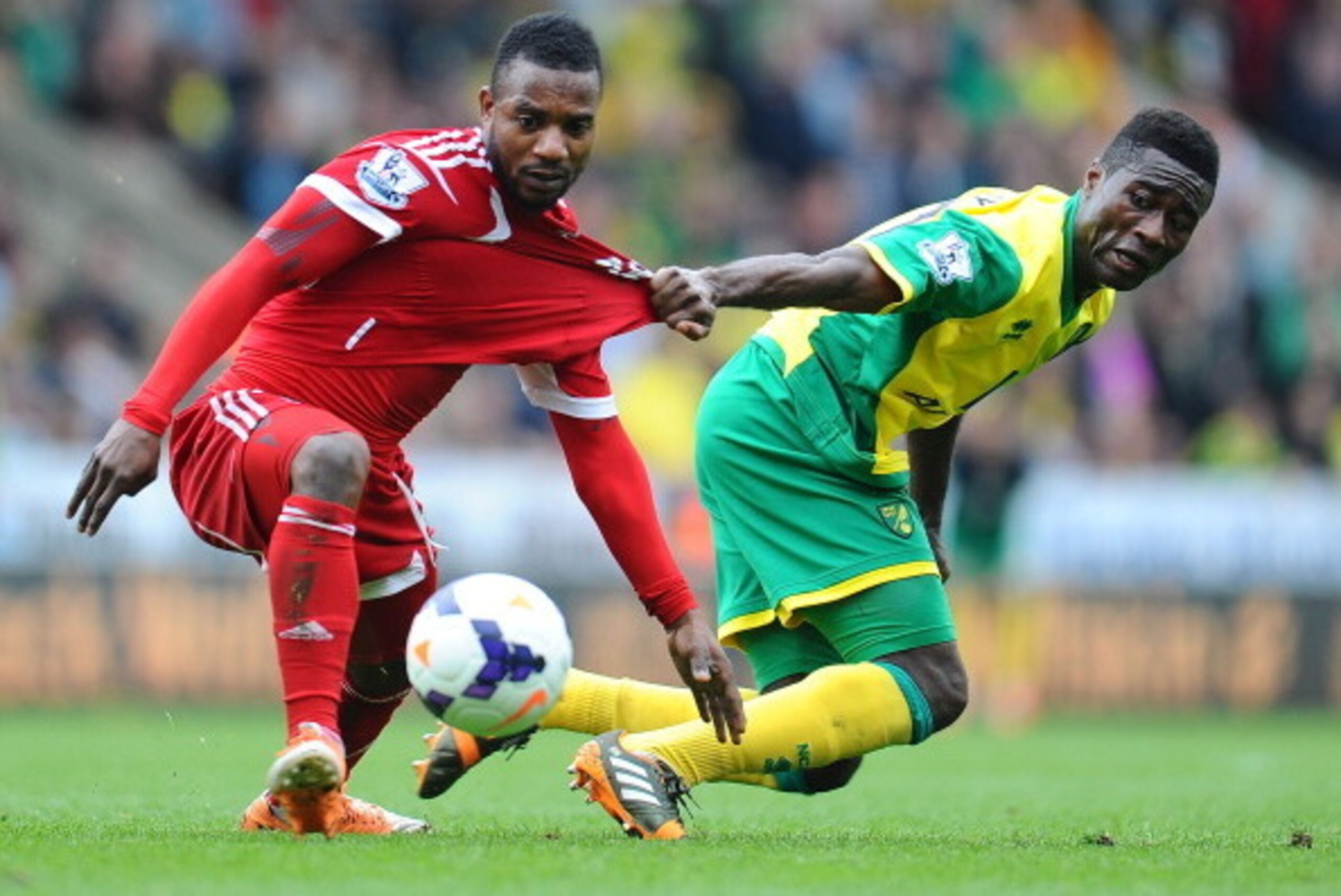 NORWICH, ENGLAND - APRIL 05: Alex Tettey of Norwich City and Stephane Sessegnon of West Bromwich Albion battle for the ball during the Barclays Premier League match between Norwich City and West Bromwich Albion at Carrow Road on April 05, 2014 in Norwich,