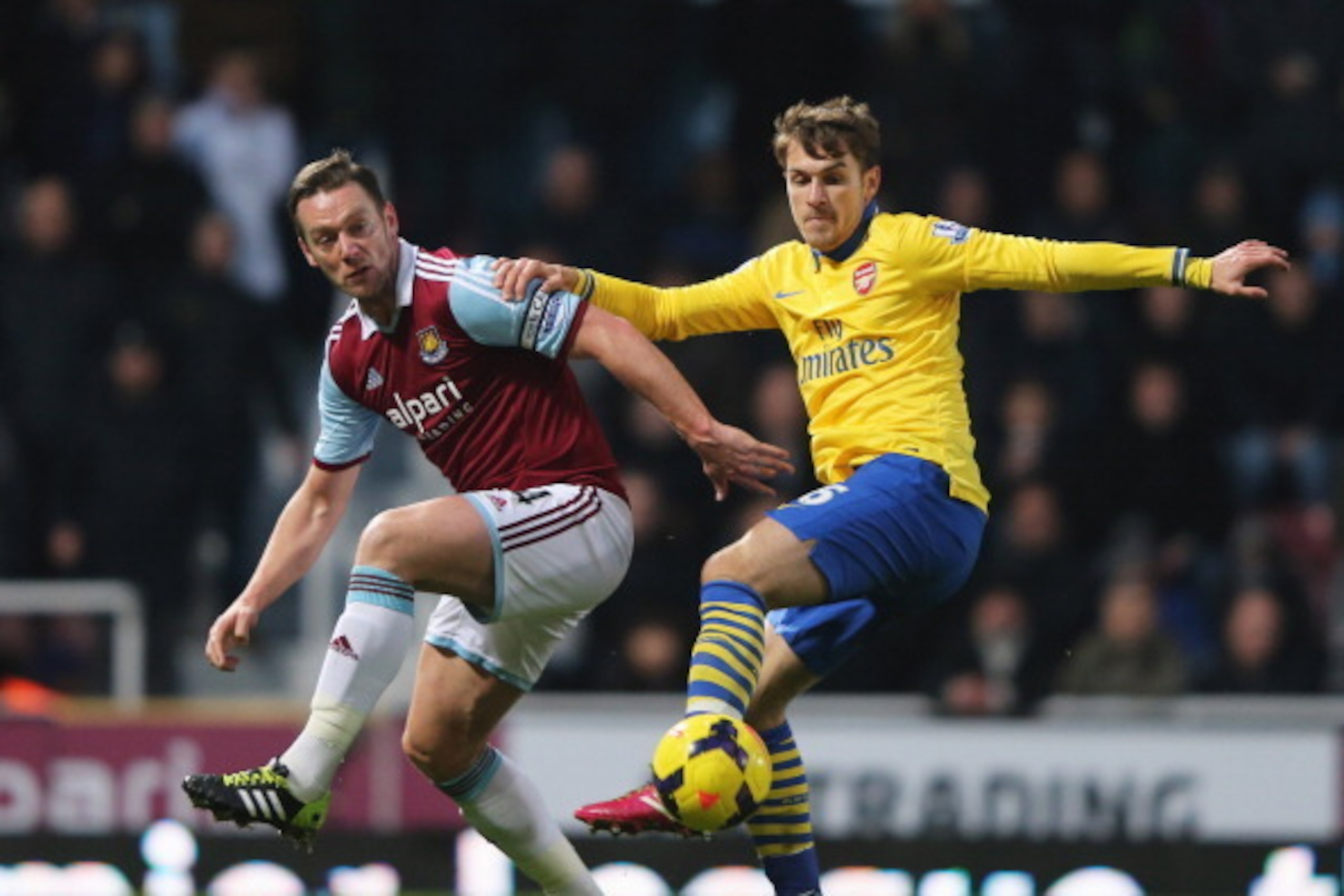 LONDON, ENGLAND - DECEMBER 26: Aaron Ramsey of Arsenal holds off Kevin Nolan of West Ham United during the Barclays Premier League match between West Ham United and Arsenal at Boleyn Ground on December 26, 2013 in London, England. (Photo by Ian Walton/G LONDON, ENGLAND - DECEMBER 26: Aaron Ramsey of Arsenal holds off Kevin Nolan of West Ham United during the Barclays Premier League match between West Ham United and Arsenal at Boleyn Ground on December 26, 2013 in London, England. (Photo by Ian Walton/G