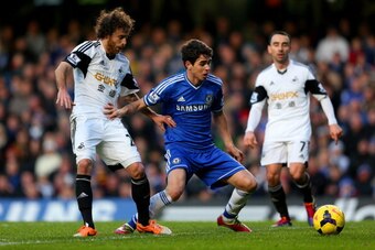 LONDON, ENGLAND - DECEMBER 26:  Oscar of Chelsea and Jose Alberto Canas of Swansea City  battle for the ball during the Barclays Premier League match between Chelsea and Swansea City at Stamford Bridge on December 26, 2013 in London, England.  (Photo by W
